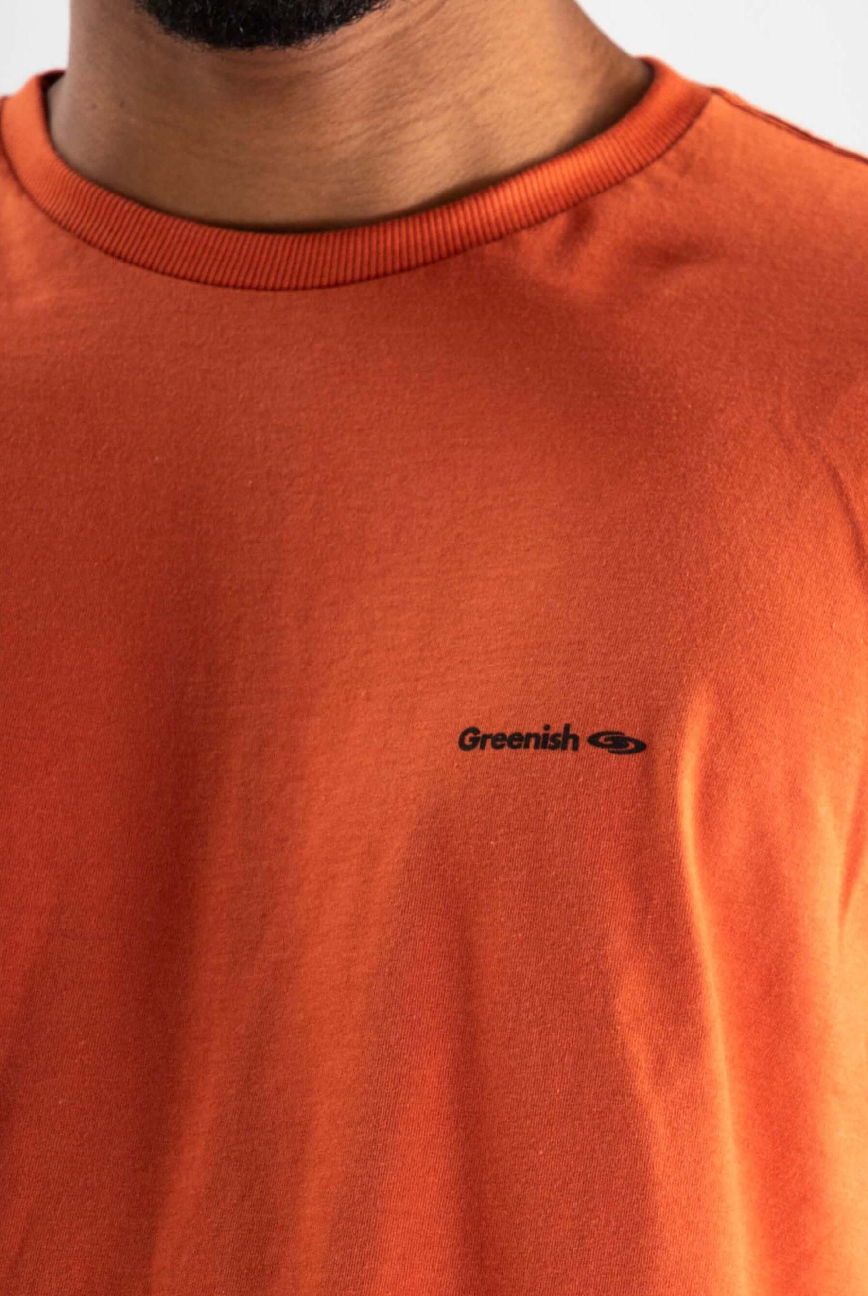 Camiseta laranja Greenish com logo minimalista, confeccionada em algodão sustentável.