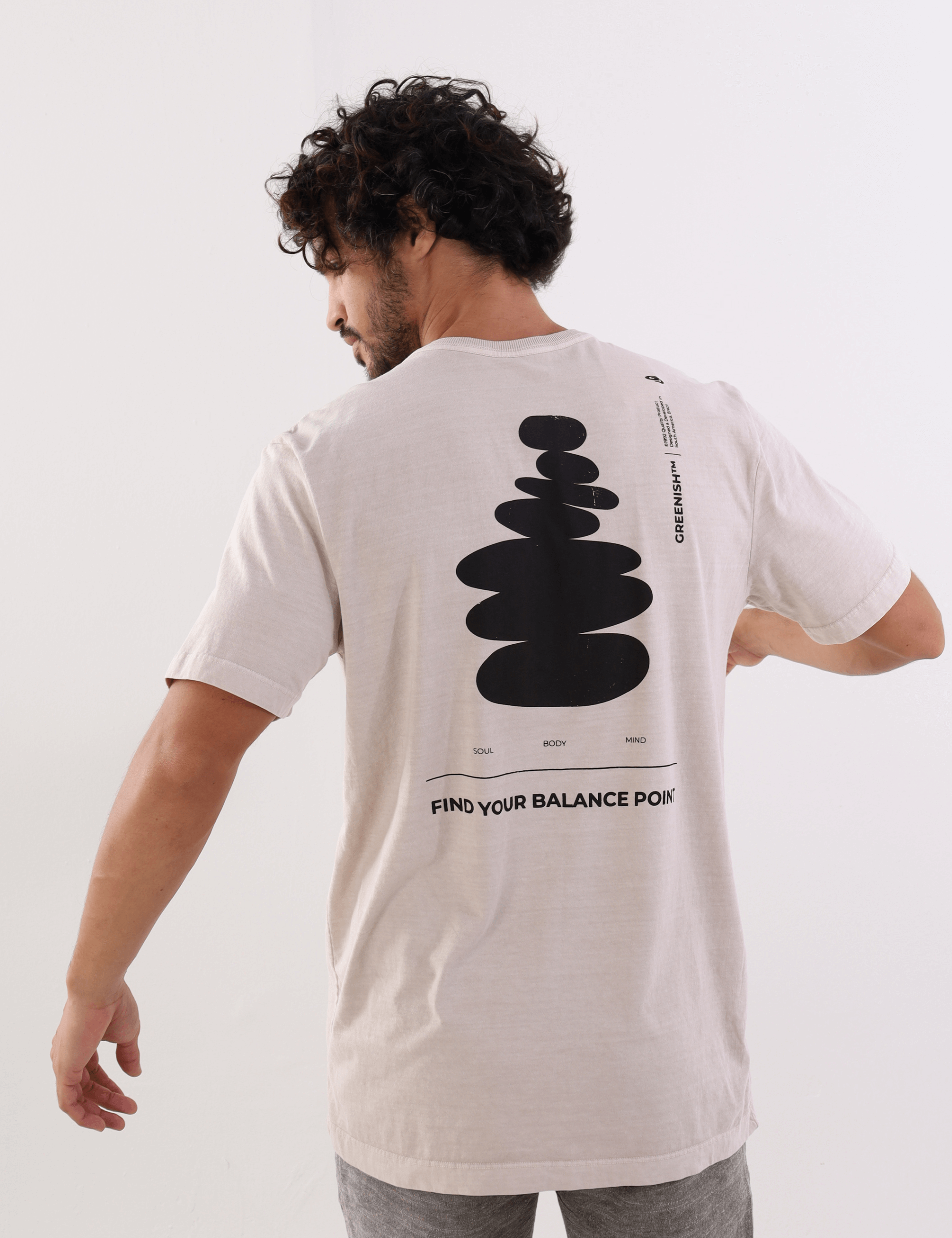 Homem usa camiseta Areia "Find Your Balance Point" da Greenish com design minimalista nas costas.
