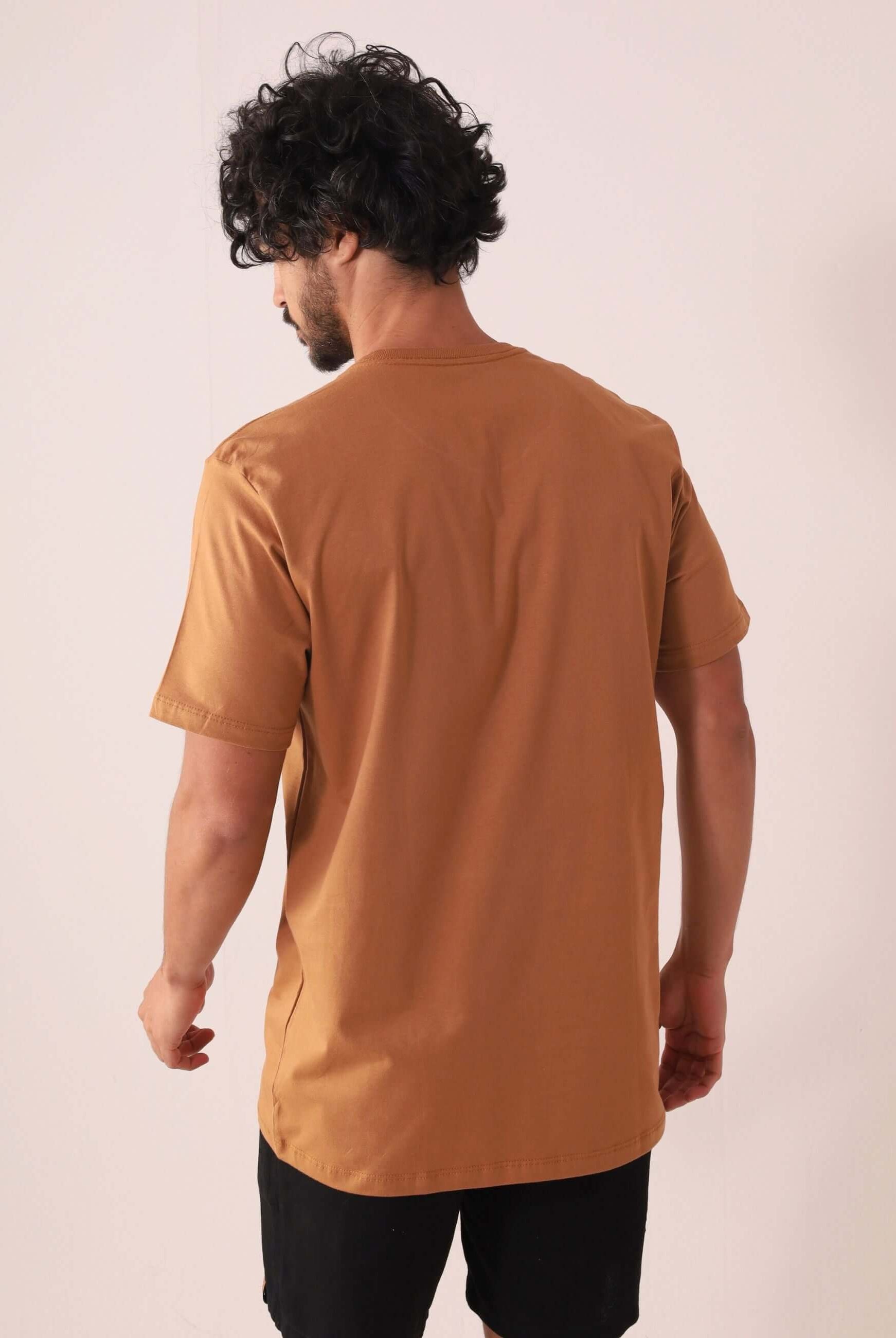 Homem vestindo CAMISETA TRADICIONAL BASIC - MARROM da Greenish, feita de algodão sustentável com selo BCI, vista traseira.