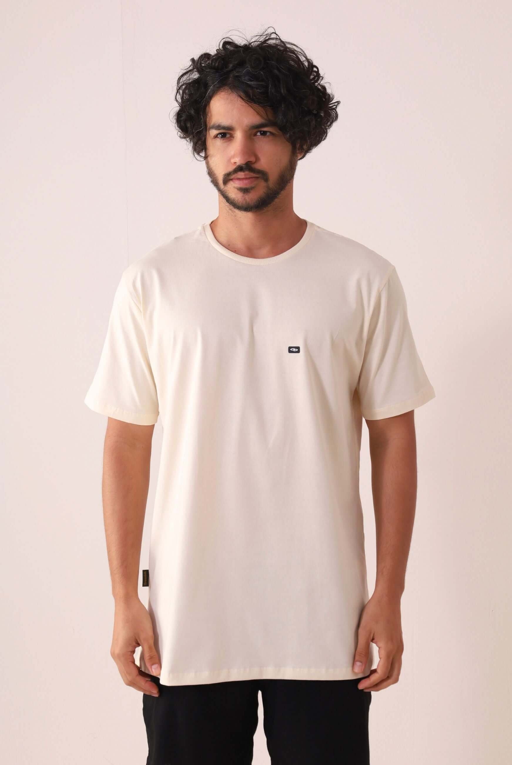 Homem vestindo CAMISETA TRADICIONAL BASIC - NATURAL da Greenish, feita com algodão sustentável e certificada pelo selo BCI.