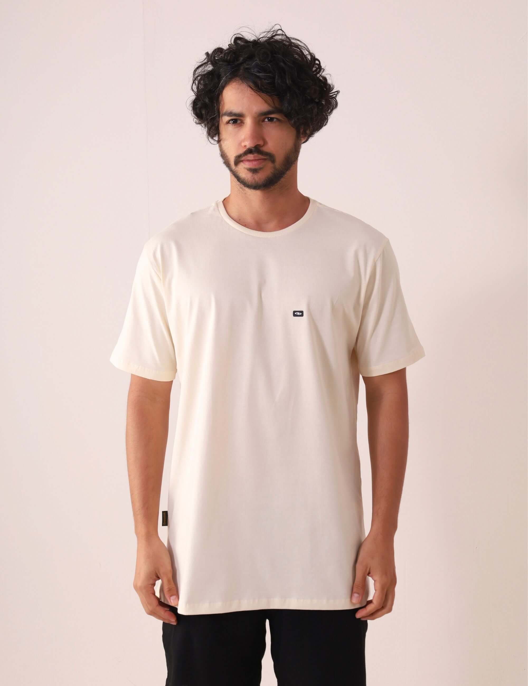 Homem vestindo CAMISETA TRADICIONAL BASIC - NATURAL da Greenish, feita com algodão sustentável e certificada pelo selo BCI.