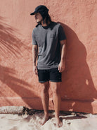 Homem usando camiseta cinza Connect To The Earth da Greenish, combinando conforto e estilo na praia.