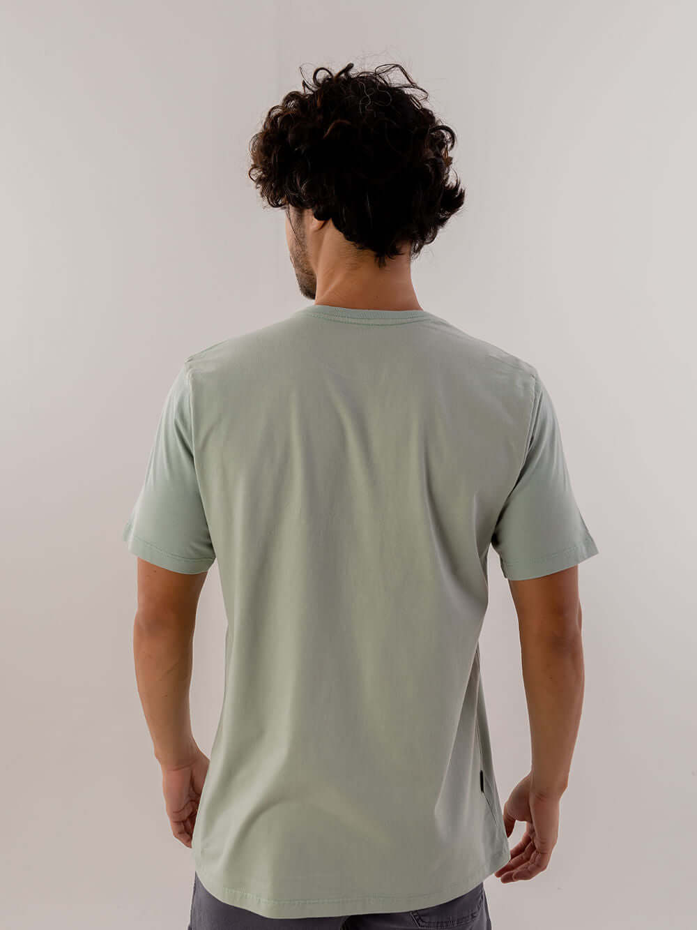 Modelando a camiseta Warning verde claro da Greenish, feita em 100% algodão e com design clássico.