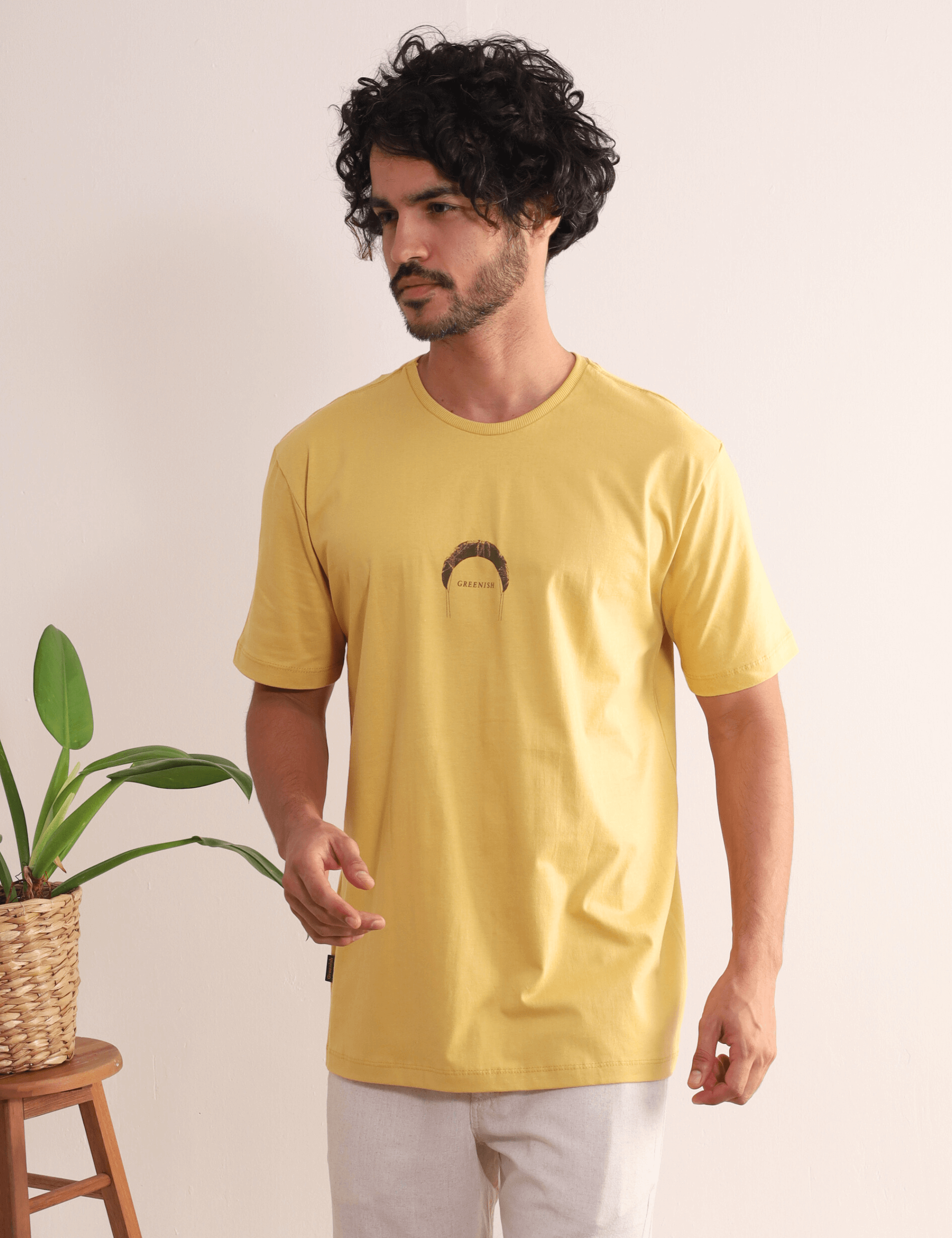 Homem vestindo Camiseta Amarelo Escuro da marca Greenish, com estampa minimalista, ideal para aventuras ao ar livre, praias e viagens.