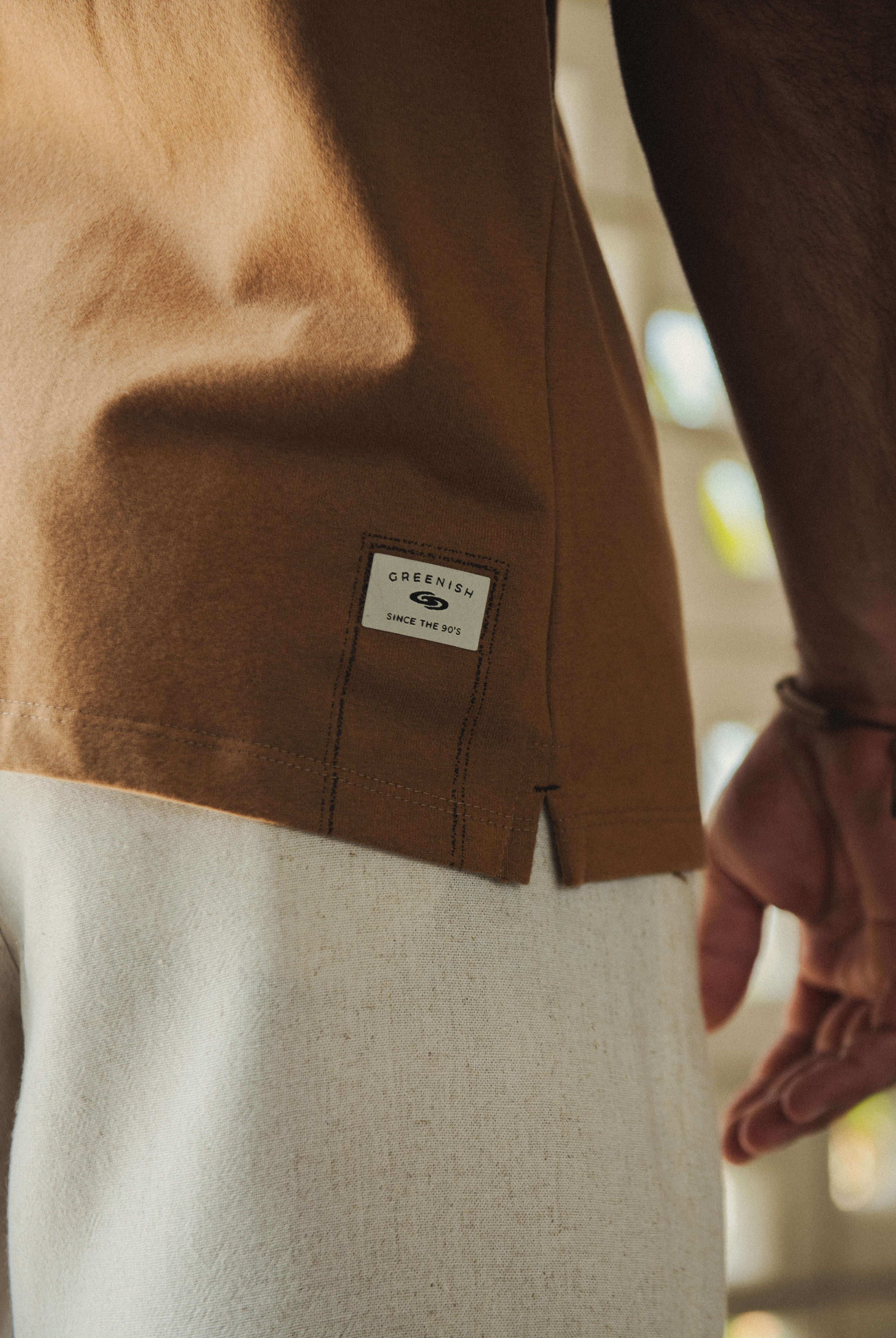 Camiseta Greenish Quality Product - Caqui com design minimalista, silk localizado e etiqueta termocolante. Ideal para o dia a dia.