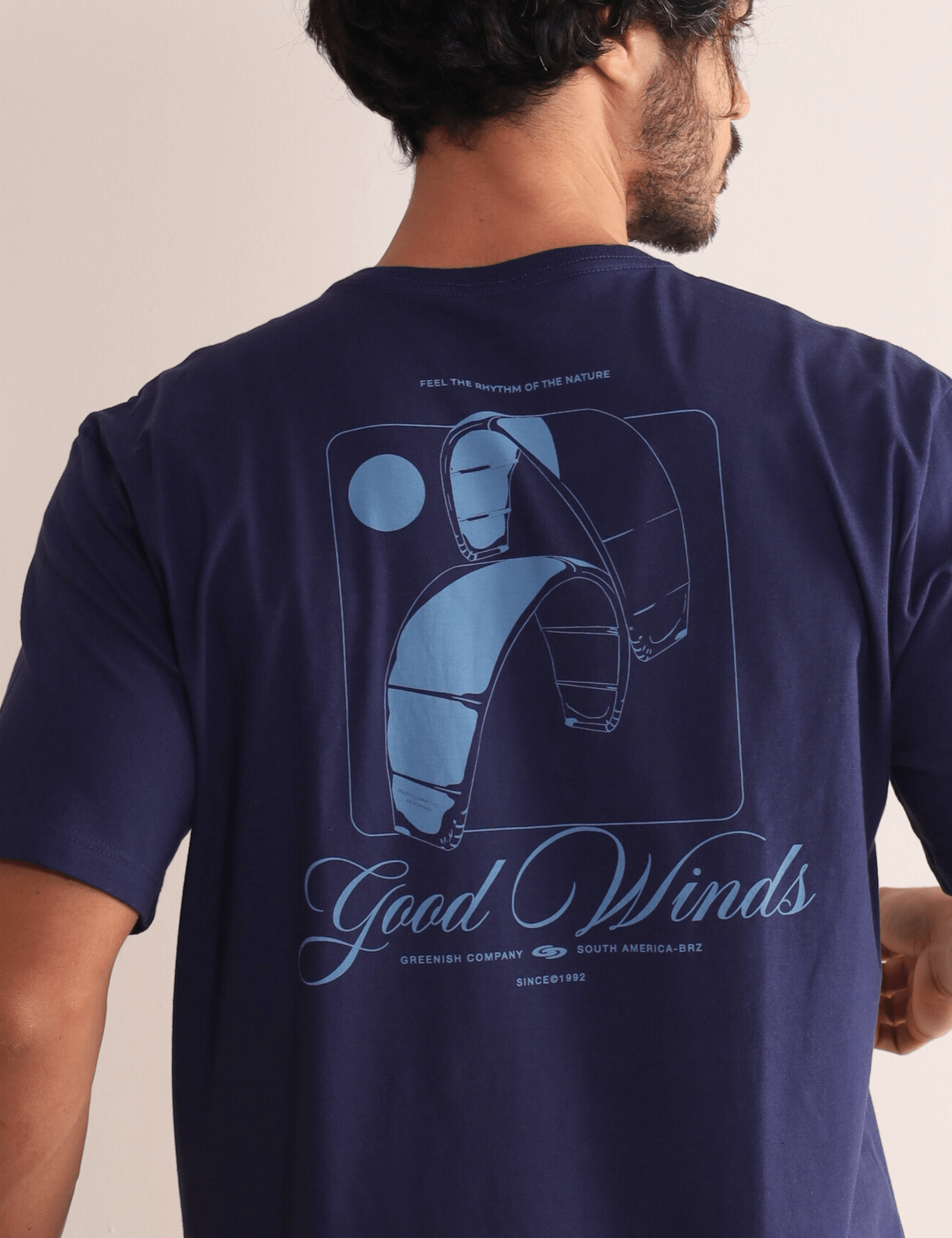 Camiseta Greenish Kites & Good Winds azul marinho, bordado frontal e silk nas costas, celebrando o kite e conexão com a natureza.