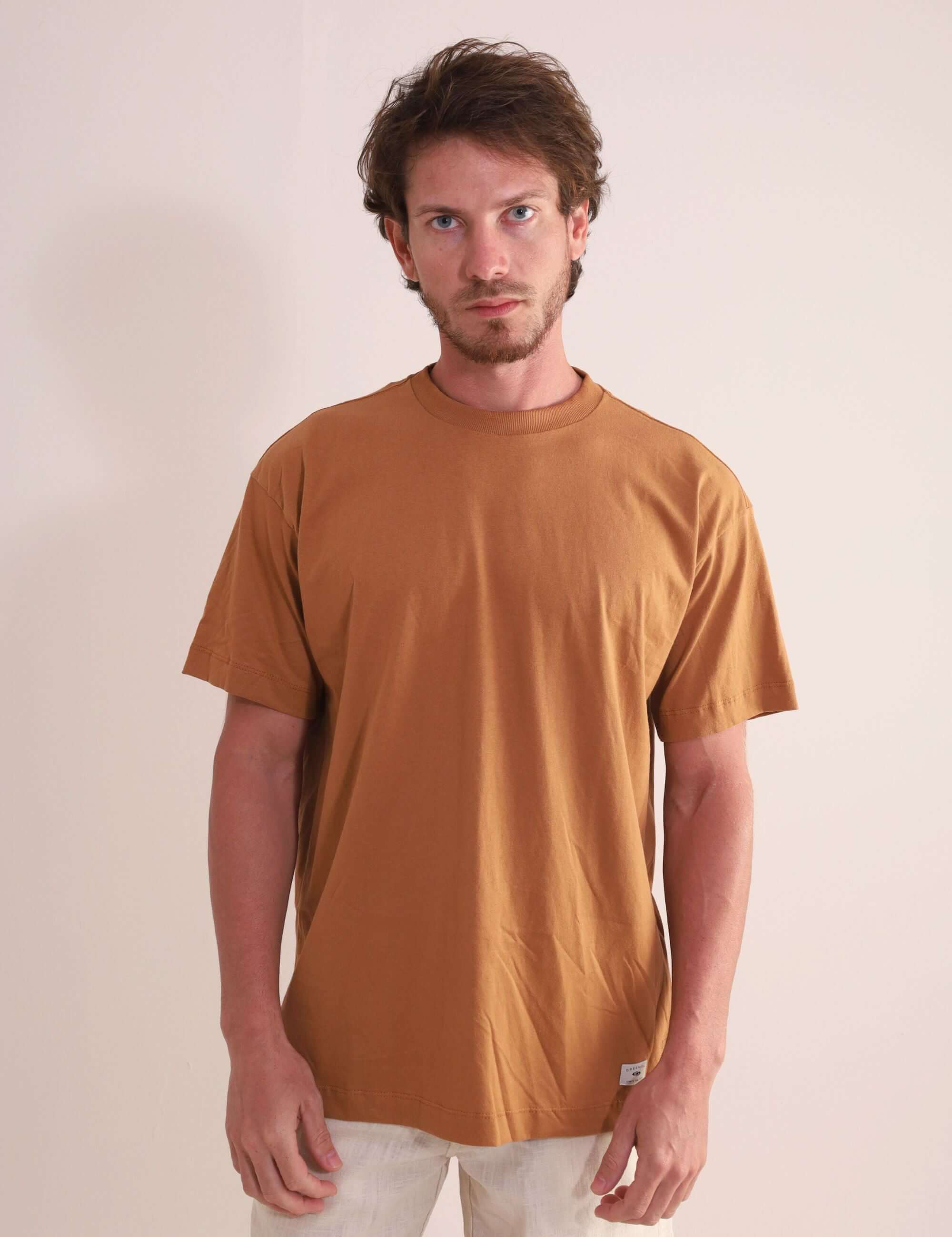 Homem vestindo Camiseta Oversized Strong - Amarelo Escuro da marca Greenish, destacando autenticidade e conforto em 100% algodão.