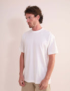 Homem vestindo Camiseta Oversized Strong - Off White da marca Greenish, feita de algodão com gola ribana larga, em ambiente casual.