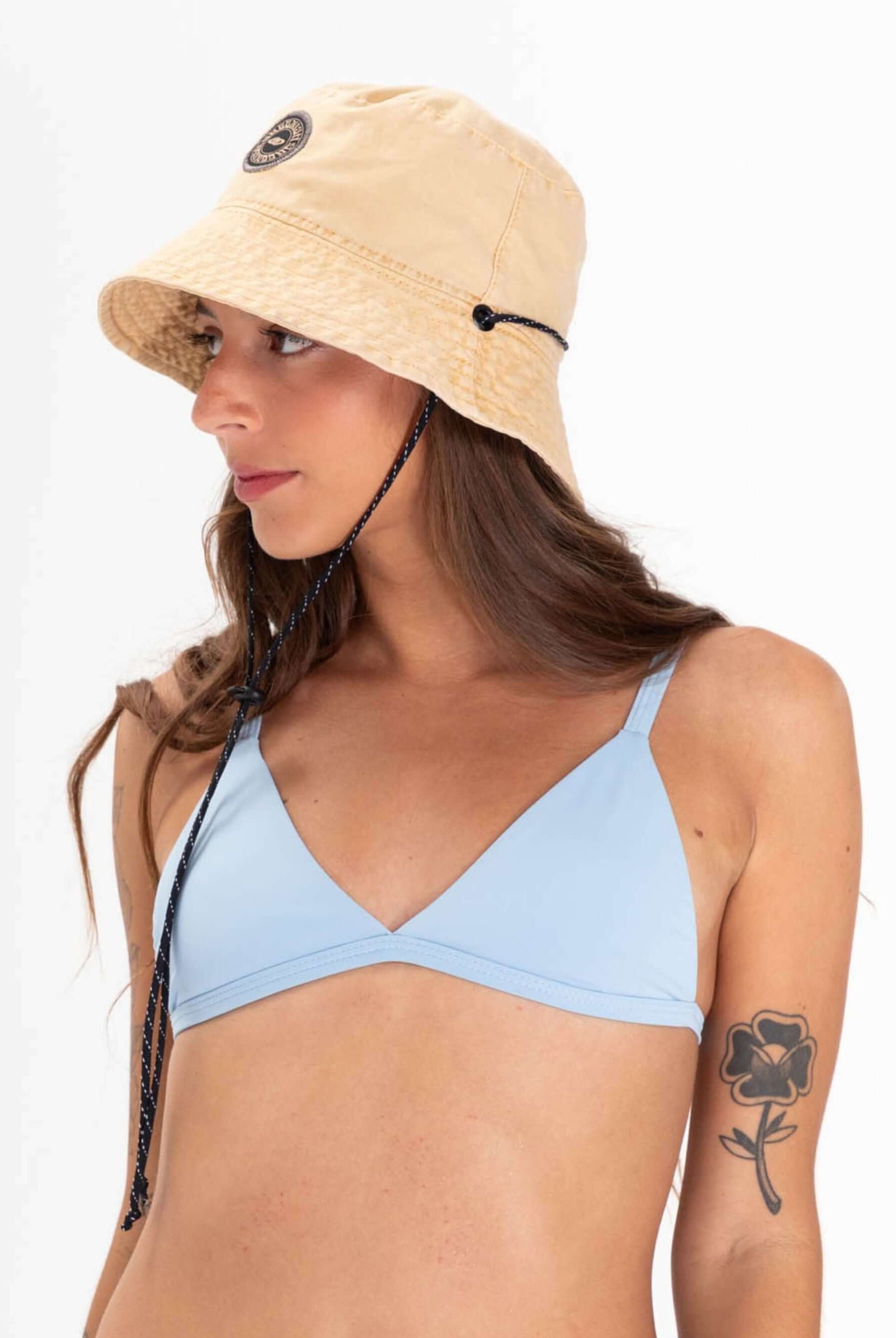 Modelo usando chapéu bucket tingido bege da marca Greenish, combinando estilo e proteção solar.