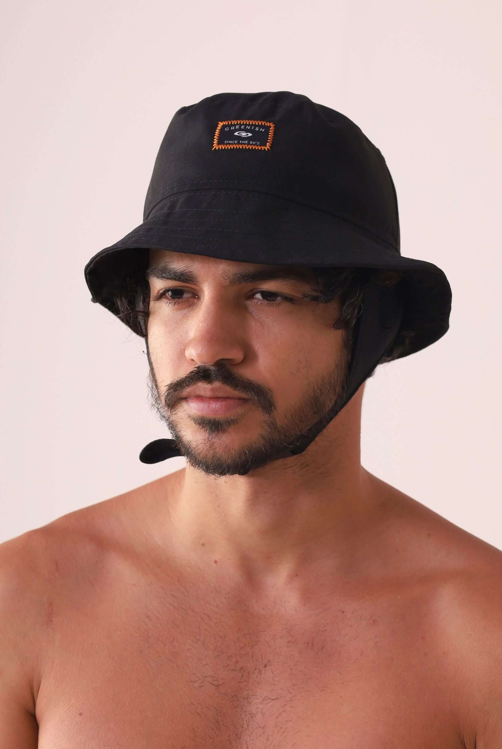 Homem usando CHAPEU BUCKET SPORT - PRETO com etiqueta Greenish e design técnico para atividades ao ar livre.