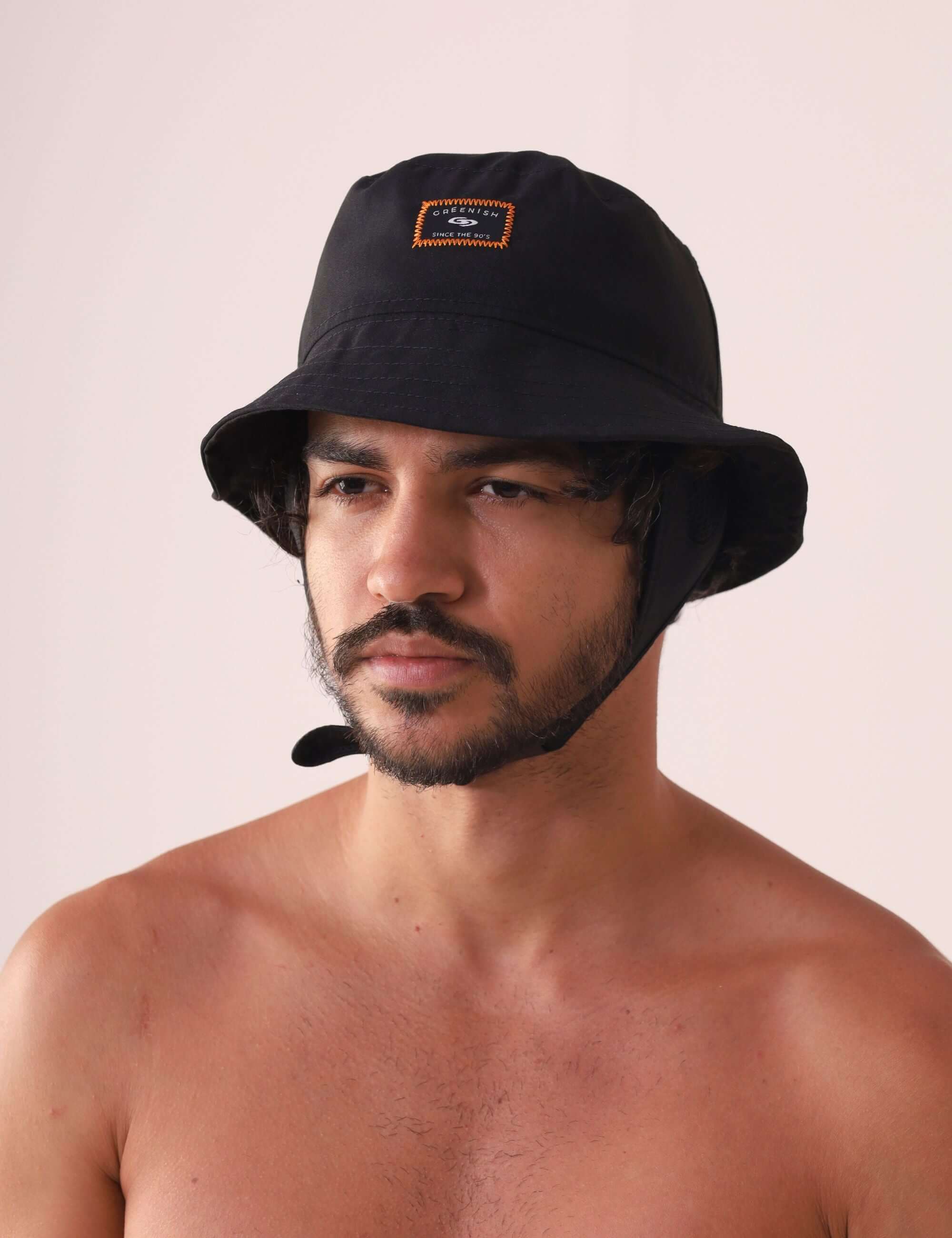 Homem usando CHAPEU BUCKET SPORT - PRETO com etiqueta Greenish e design técnico para atividades ao ar livre.