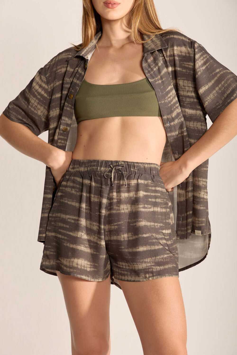 Model wearing a stylish set featuring a patterned shirt and matching shorts, ideal for casual summer outings.