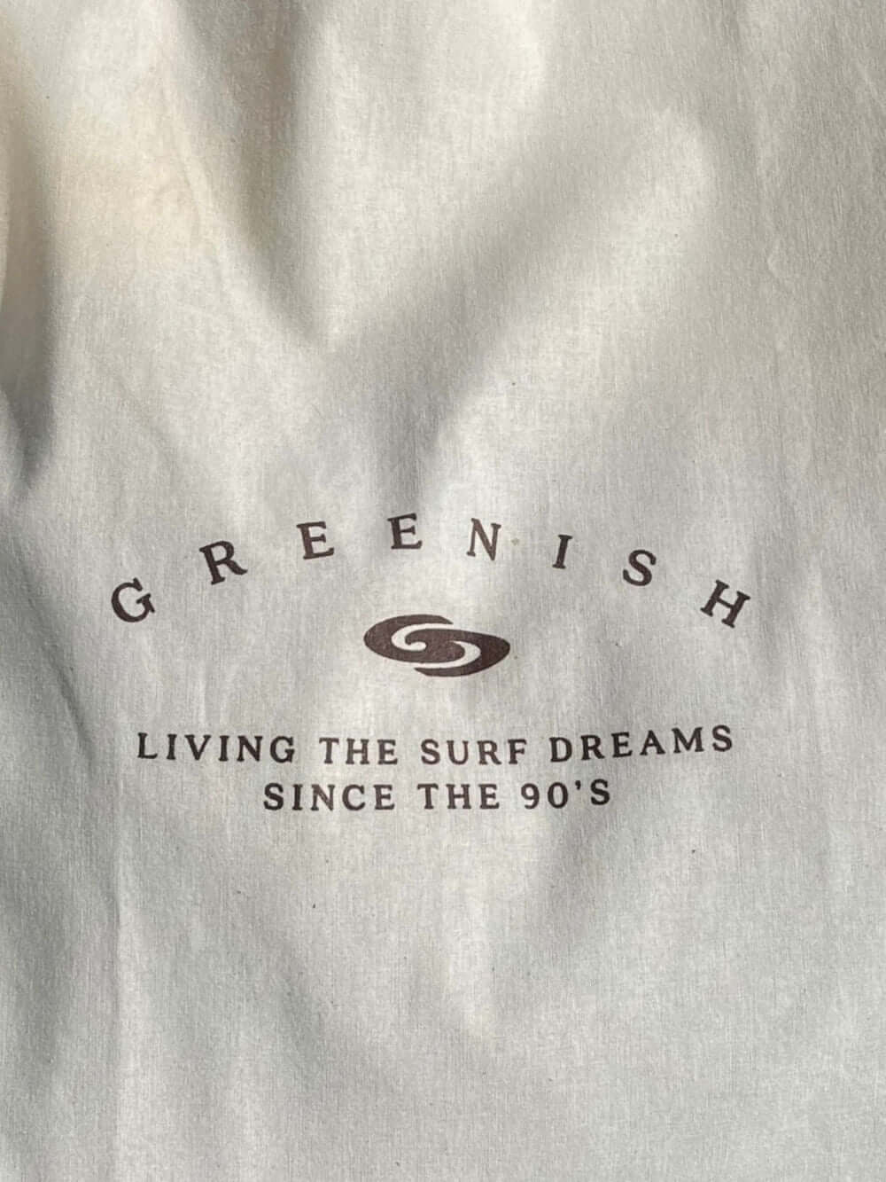 Logotipo da Greenish com a frase 'Living the surf dreams since the 90's' em fundo claro.