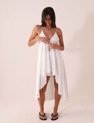 Mulher usando Blusa Áurea - Off White da Greenish, modelagem fluida e alças ajustáveis, ideal para dias de sol, feita 100% de viscose.