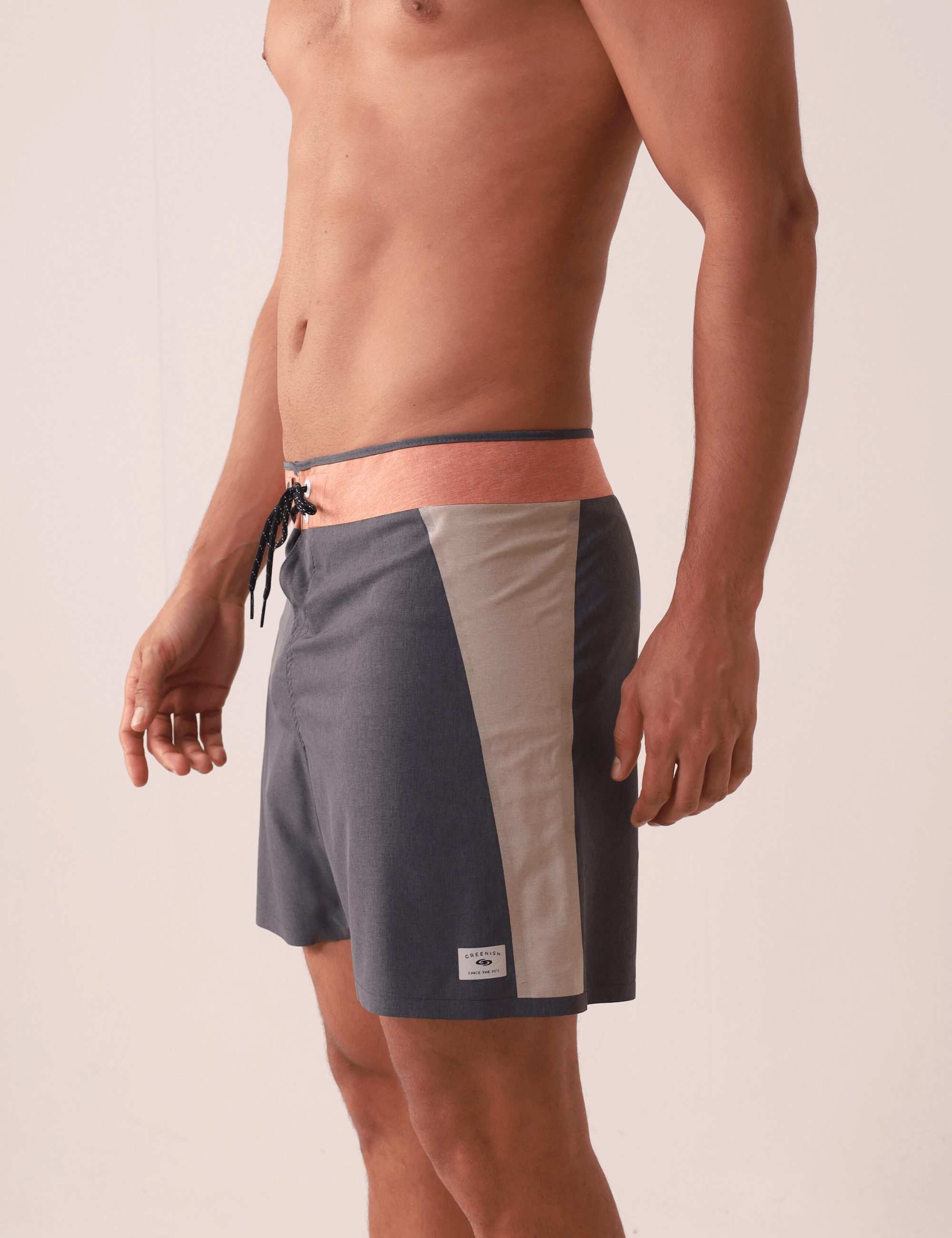 Homem vestindo Boardshort Ultralight II Sunset - Preto da marca Greenish, com design multicolorido e recortes colados sem costura.