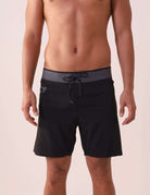 Homem usando Boardshort Ultralight II Ocean - Preto da Greenish, tecido leve, secagem rápida, com bolso lateral e cós anatômico.