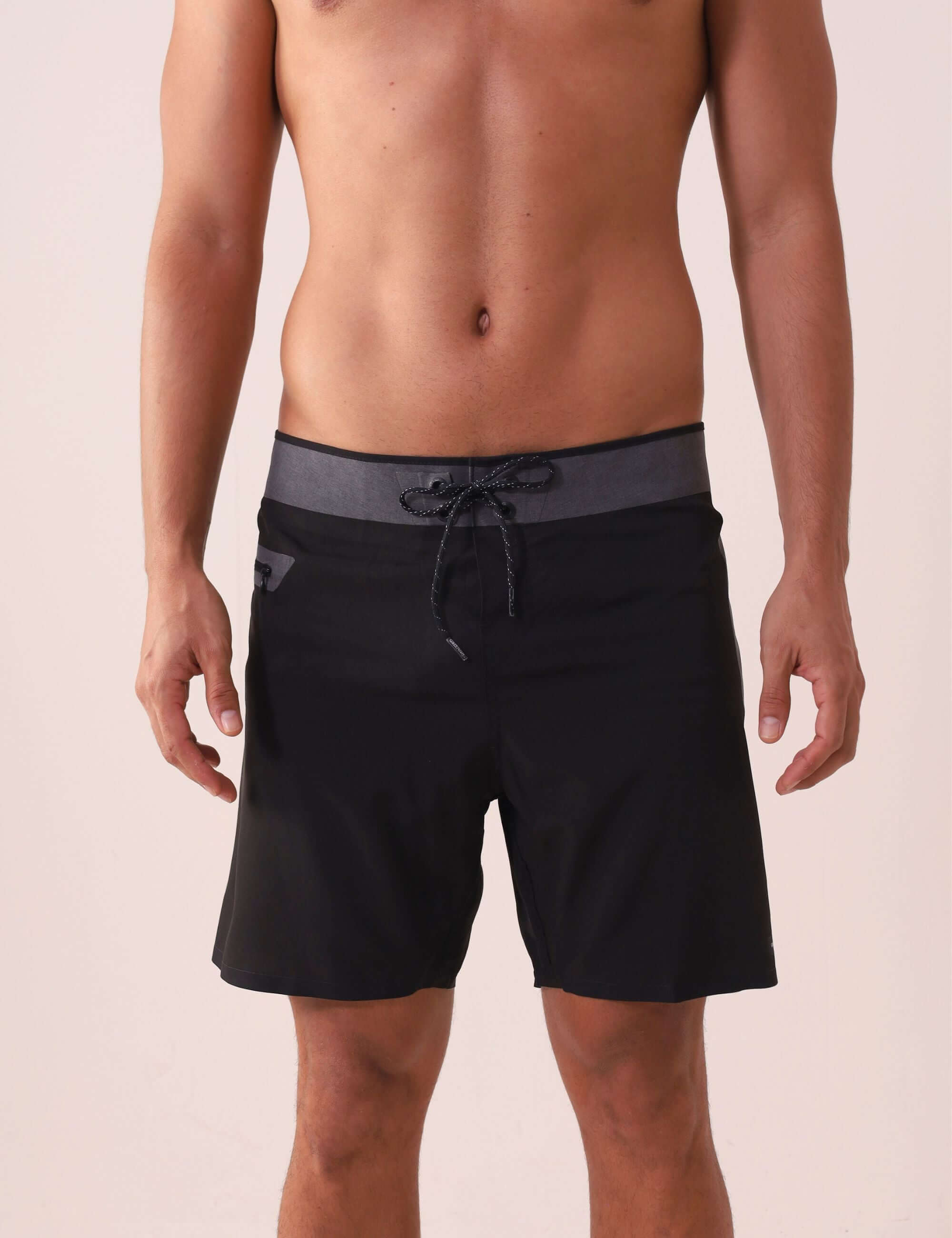 Homem usando Boardshort Ultralight II Ocean - Preto da Greenish, tecido leve, secagem rápida, com bolso lateral e cós anatômico.