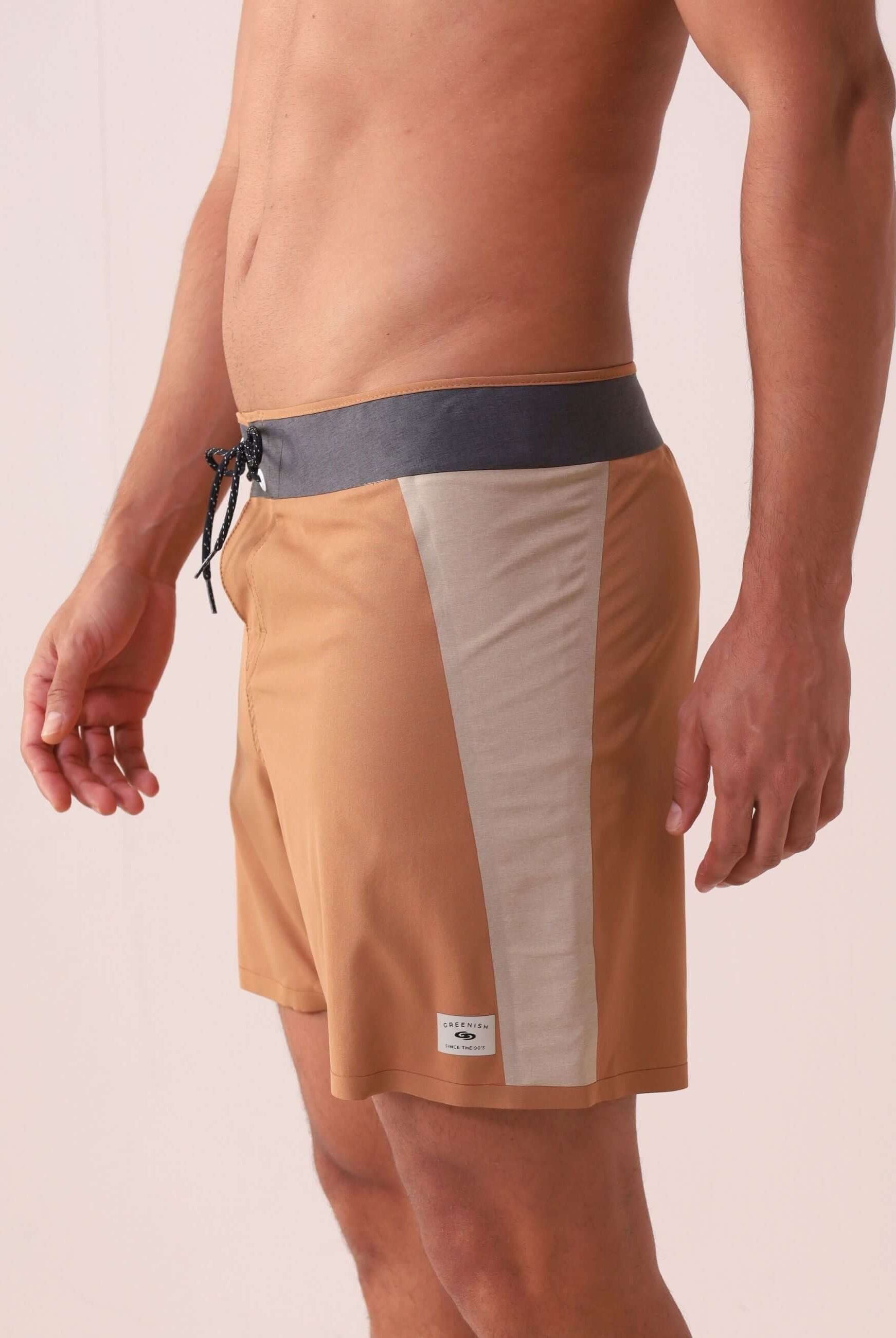 Homem vestindo o Boardshort Ultralight II Sunset - Caqui da marca Greenish, ideal para movimento e estilo autêntico.
