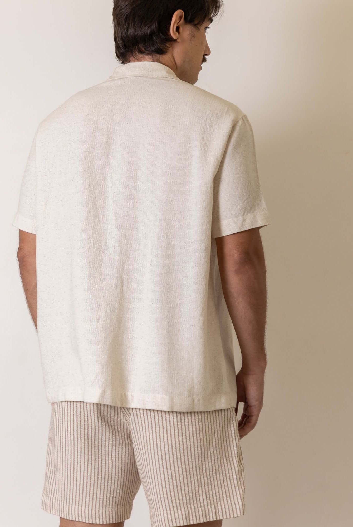 Modelo vestindo Camisa Botao Brisa - Natural da Greenish, vista traseira