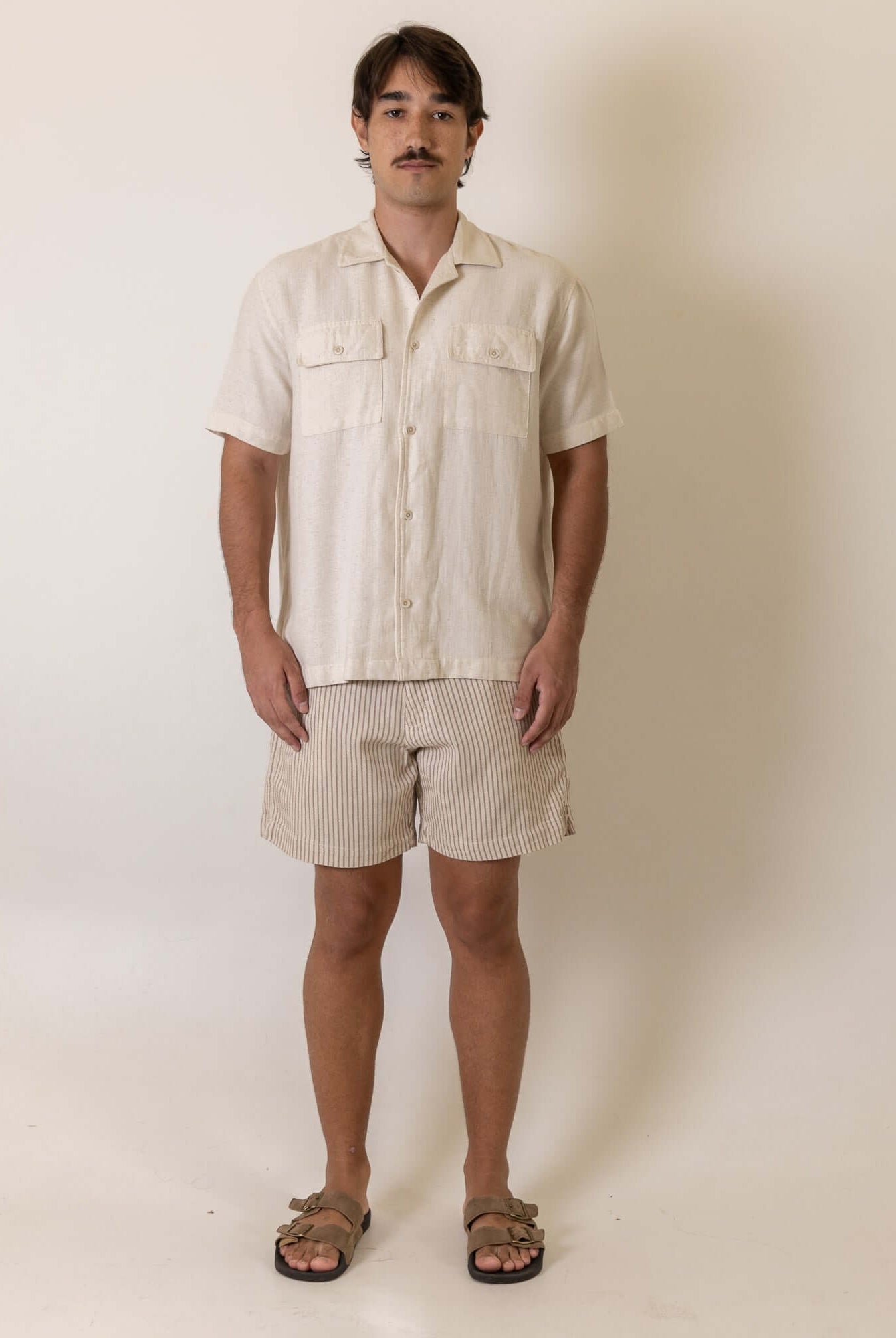 Greenish Camisa Botao Brisa - Natural worn by a model, showcasing the natural color and button detail in a casual setting.