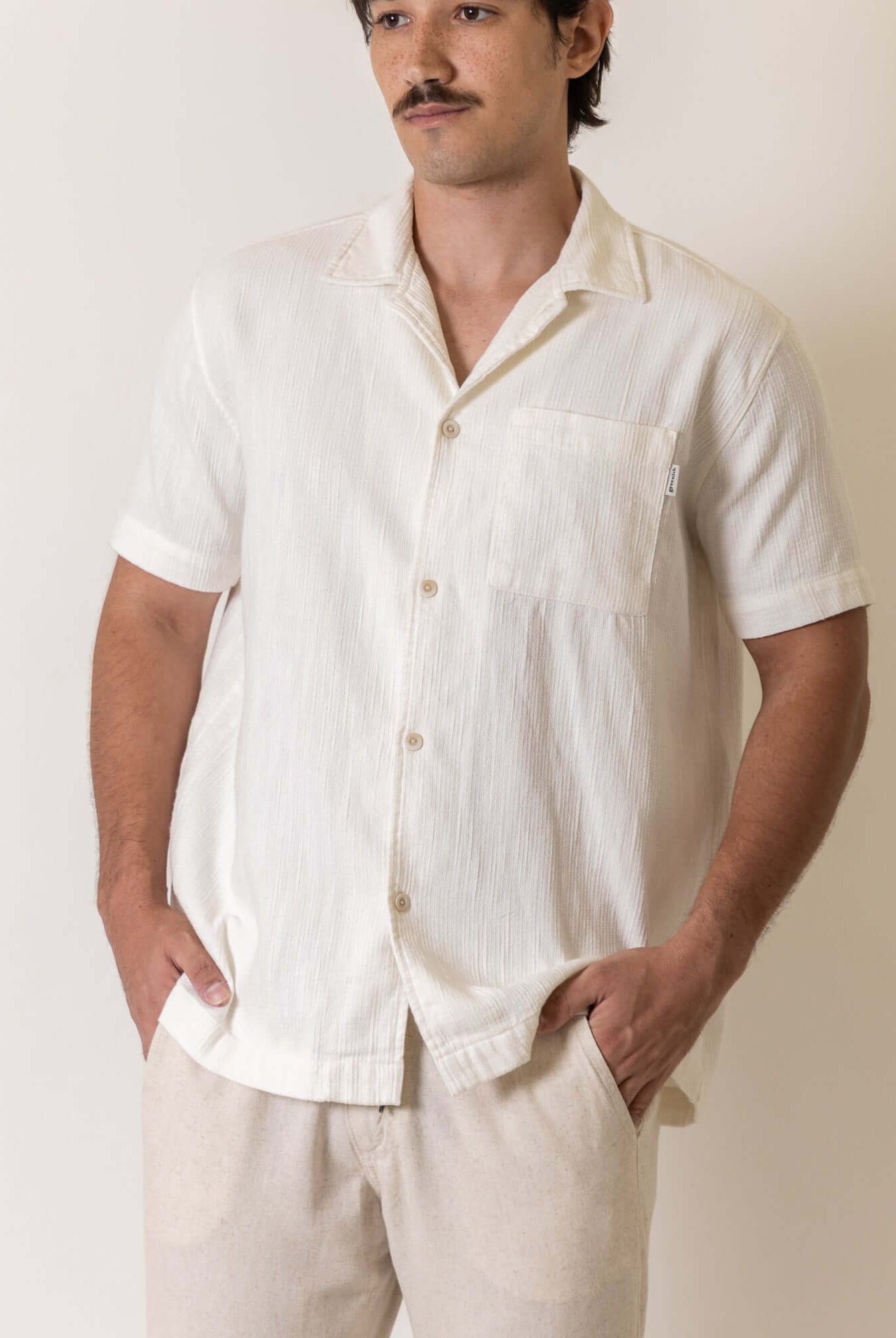 Camisa Botao High Tide - Off White by Greenish worn by a male model, showcasing its casual style and design.