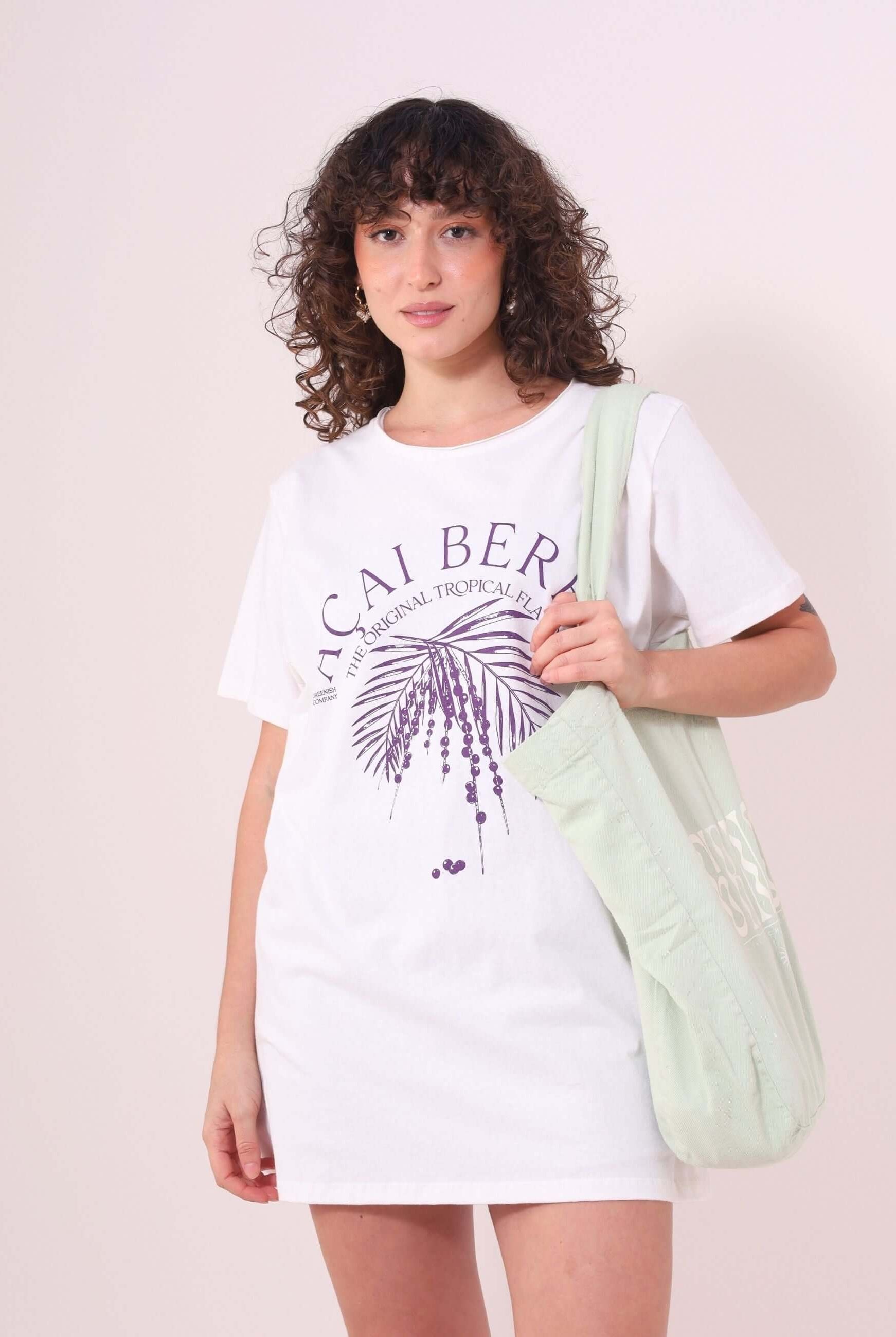 Mulher vestindo Camiseta Açai Berry da Greenish, off white, 100% algodão, estilo despojado e confortável com estampa tropical.