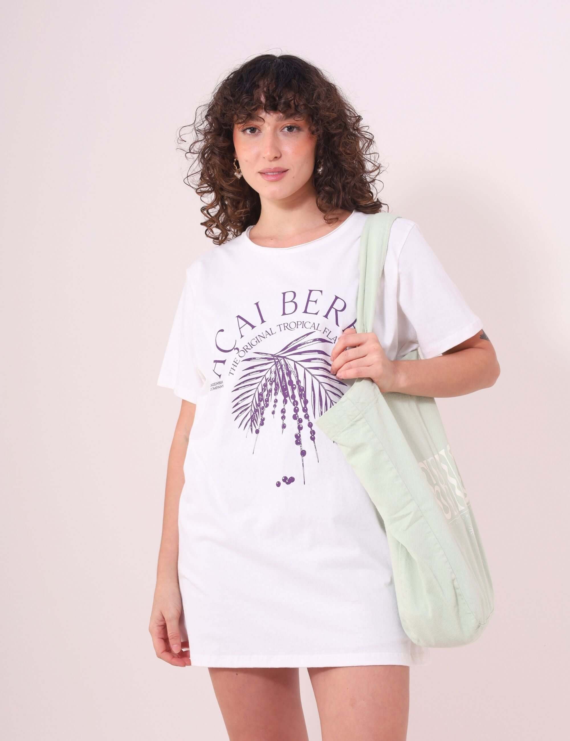 Mulher vestindo Camiseta Açai Berry da Greenish, off white, 100% algodão, estilo despojado e confortável com estampa tropical.