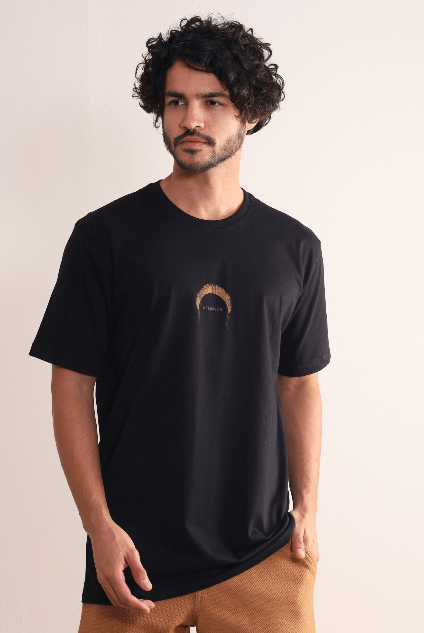 Homem vestindo camiseta preta Greenish Find Out New Places com estampa minimalista, ideal para aventuras ao ar livre e dias de praia.