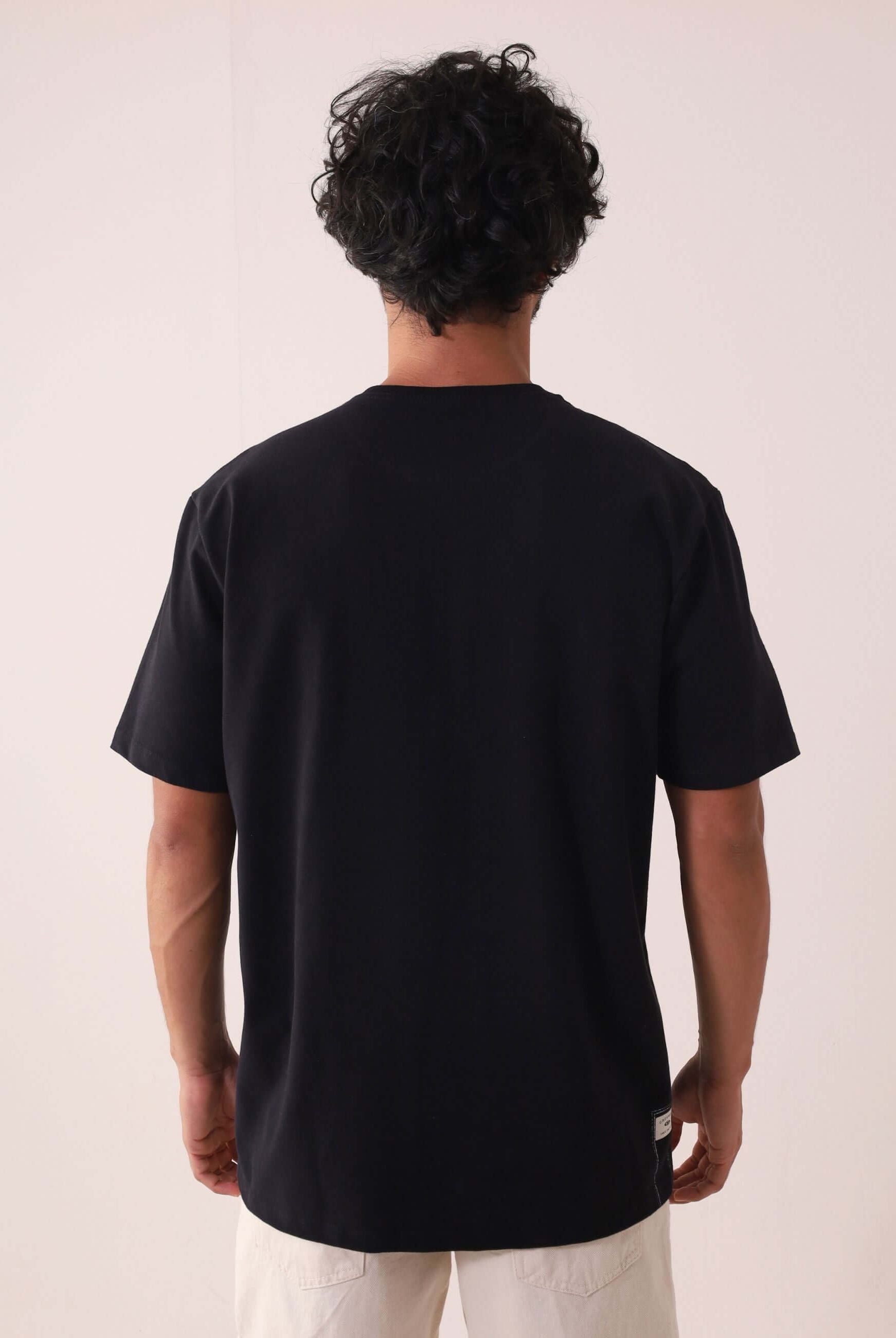 Camiserta Greenish Quality Product - Preto, camiseta com design clean e etiqueta termocolante, modelo de costas. Marca Greenish.