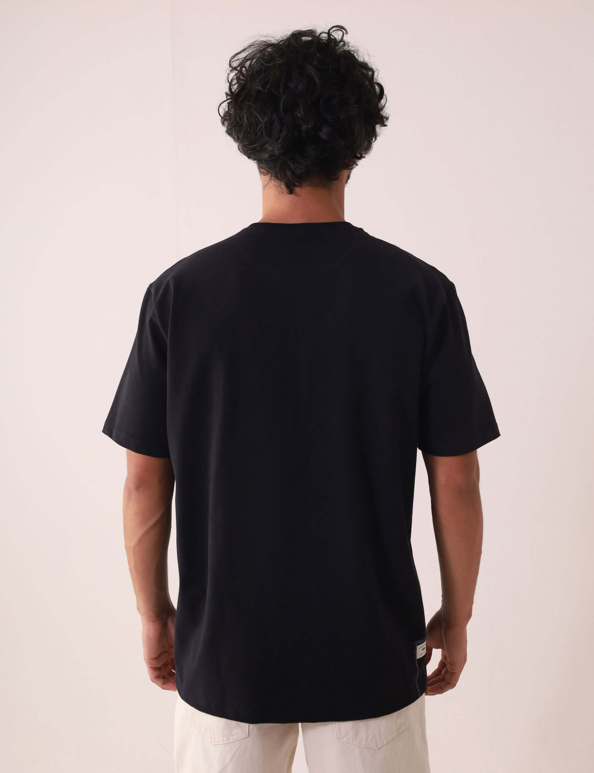 Camiserta Greenish Quality Product - Preto, camiseta com design clean e etiqueta termocolante, modelo de costas. Marca Greenish.