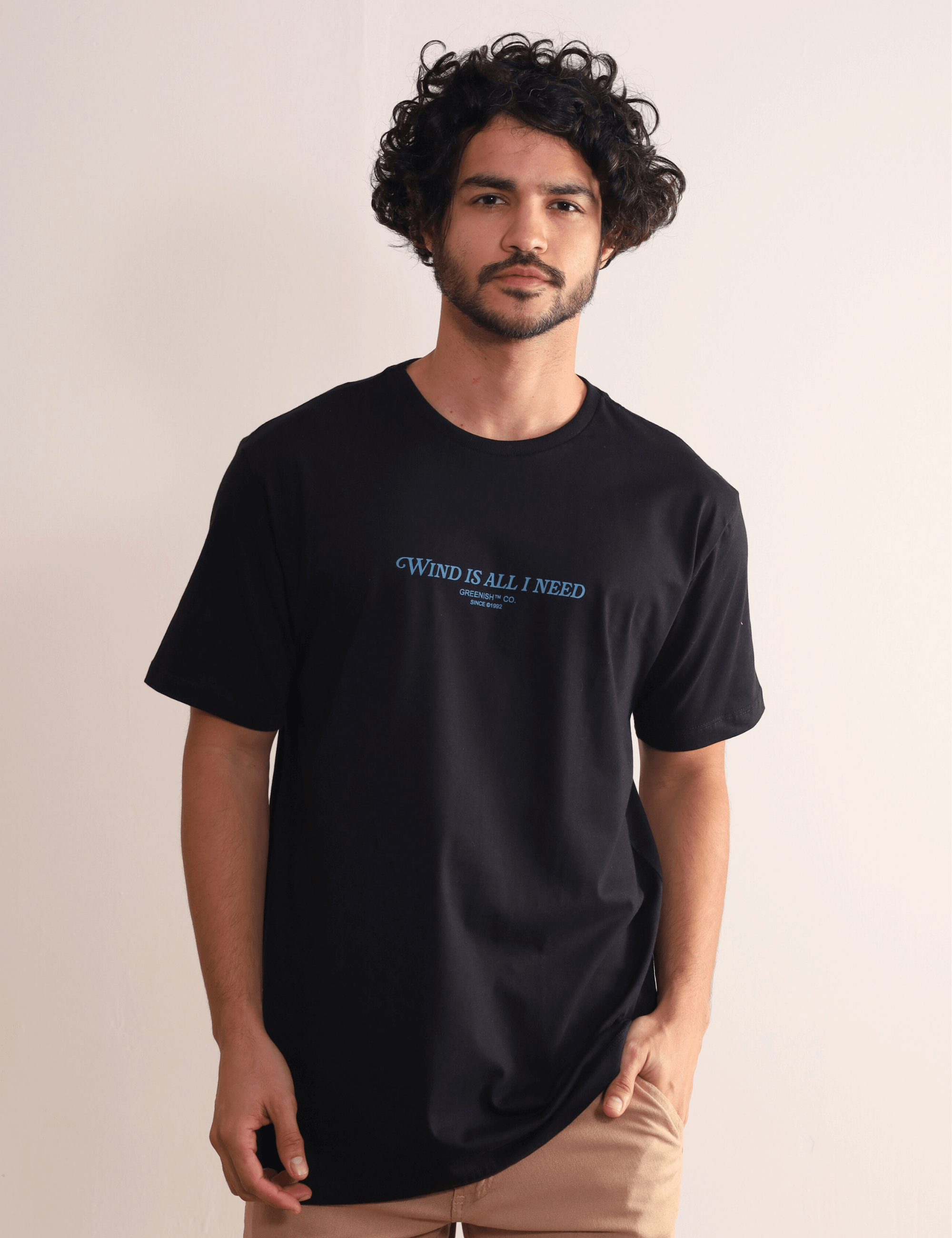Camiseta preta Greenish 'Wind Is All I Need' com modelagem confortável e estampa frontal, perfeita para estilo e conforto.