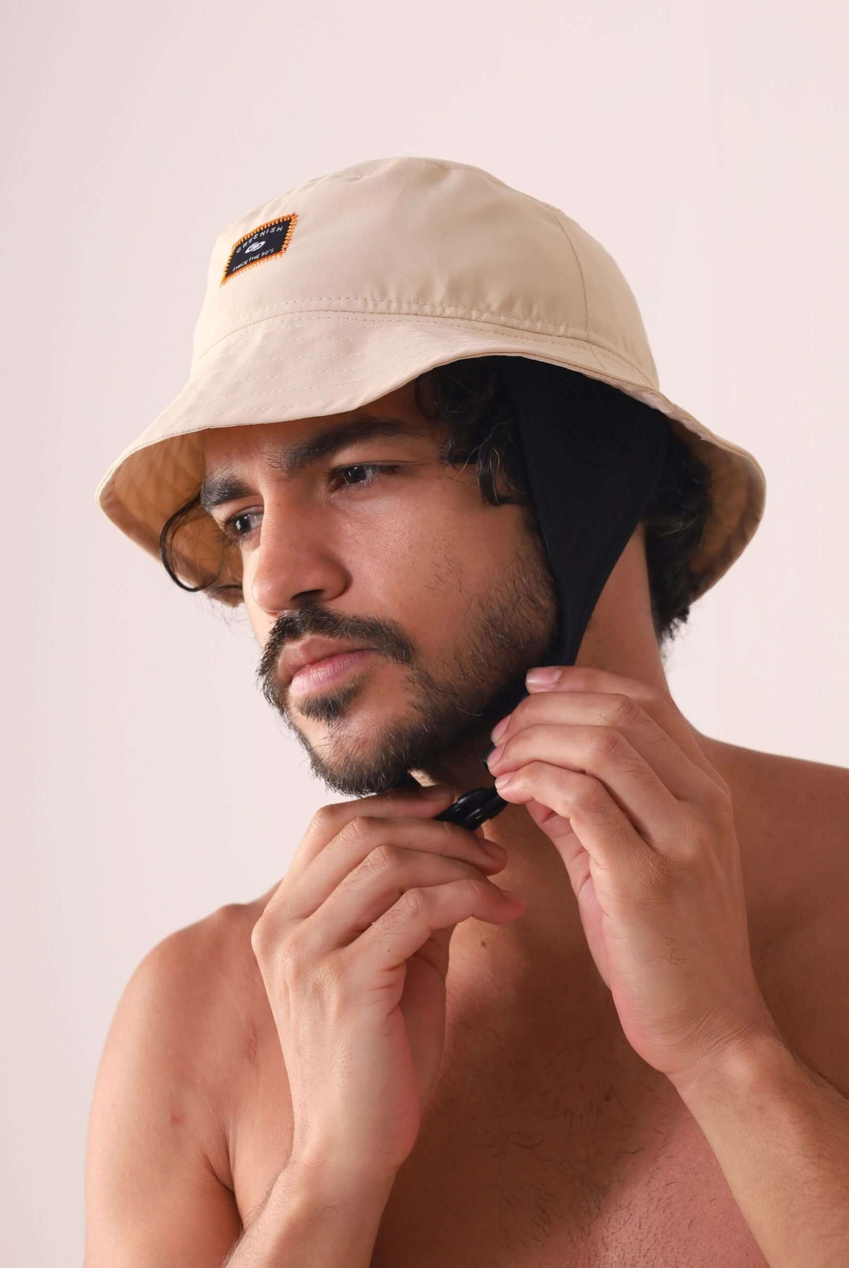 Homem usando Chapeu Bucket Sport - Bege da Greenish com cordão de neoprene ajustável para conforto ao ar livre.