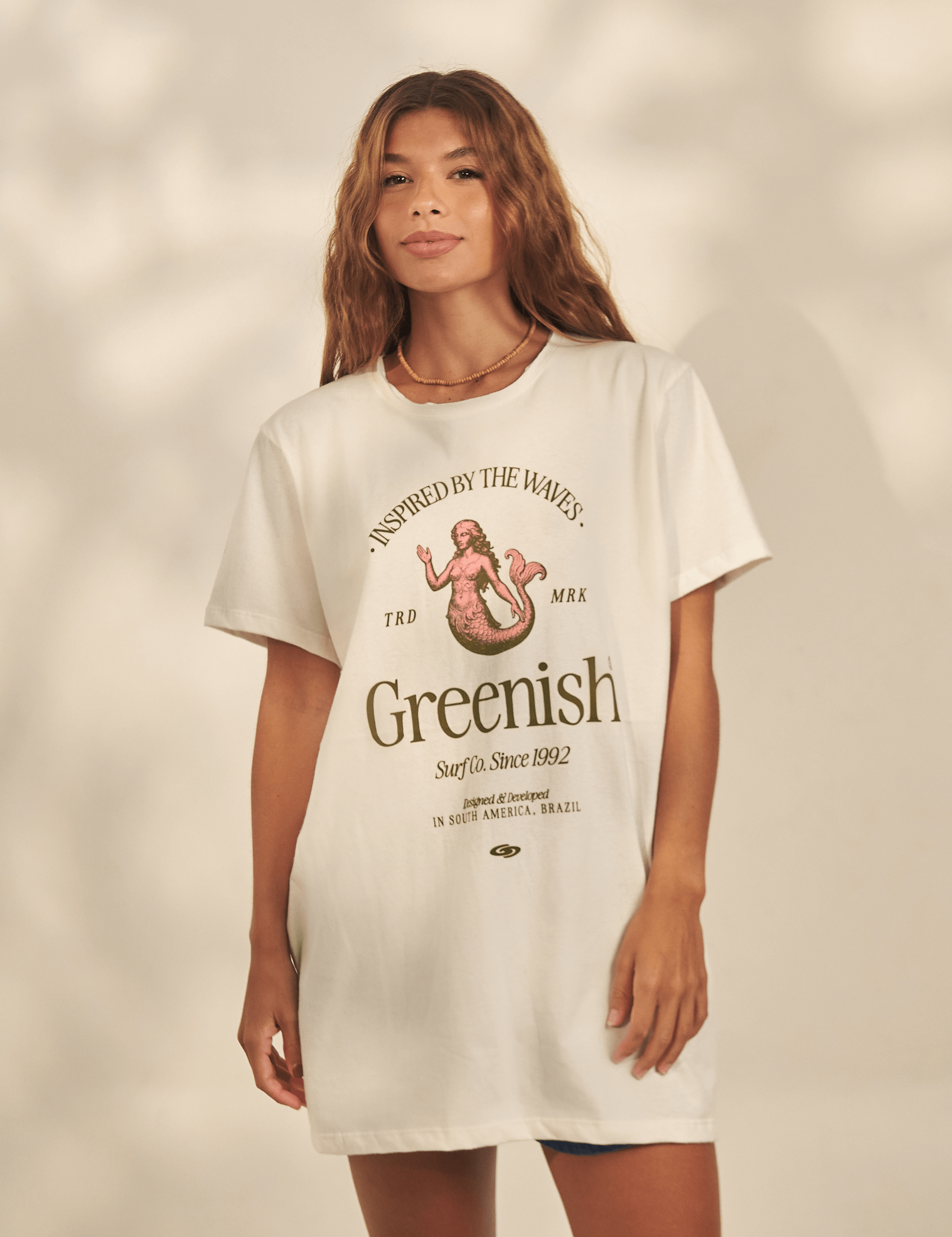 Alt Tag: Maxi Camiseta Mermaid - Off White da Greenish, modelo com estampa sereia, shape amplo em malha 100% algodão, look pra praia