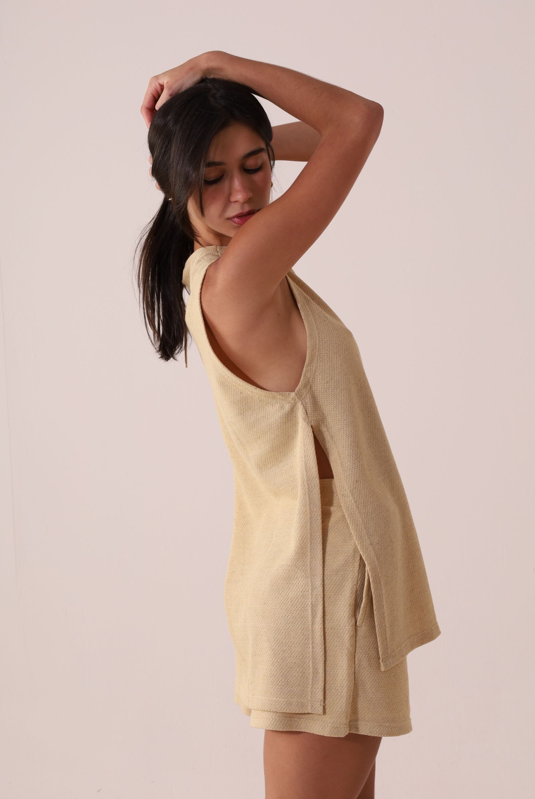 Modelo usando REGATA FUTURE - BEGE com shorts, estilo leve e natural da marca Greenish, ideal para dias quentes e looks casuais sofisticados.