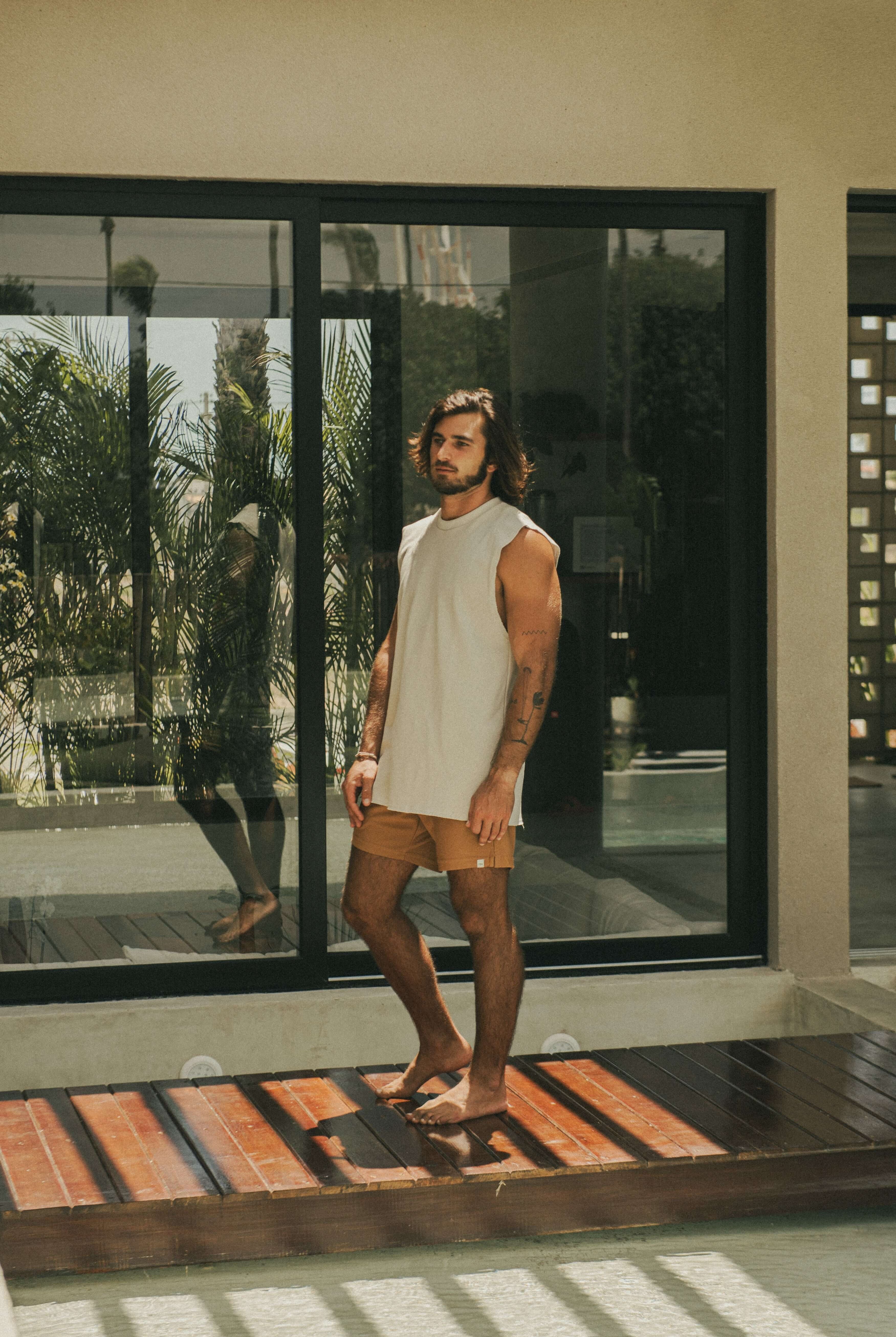 Homem usando Regata Larga Waves - Bege da marca Greenish em ambiente moderno.