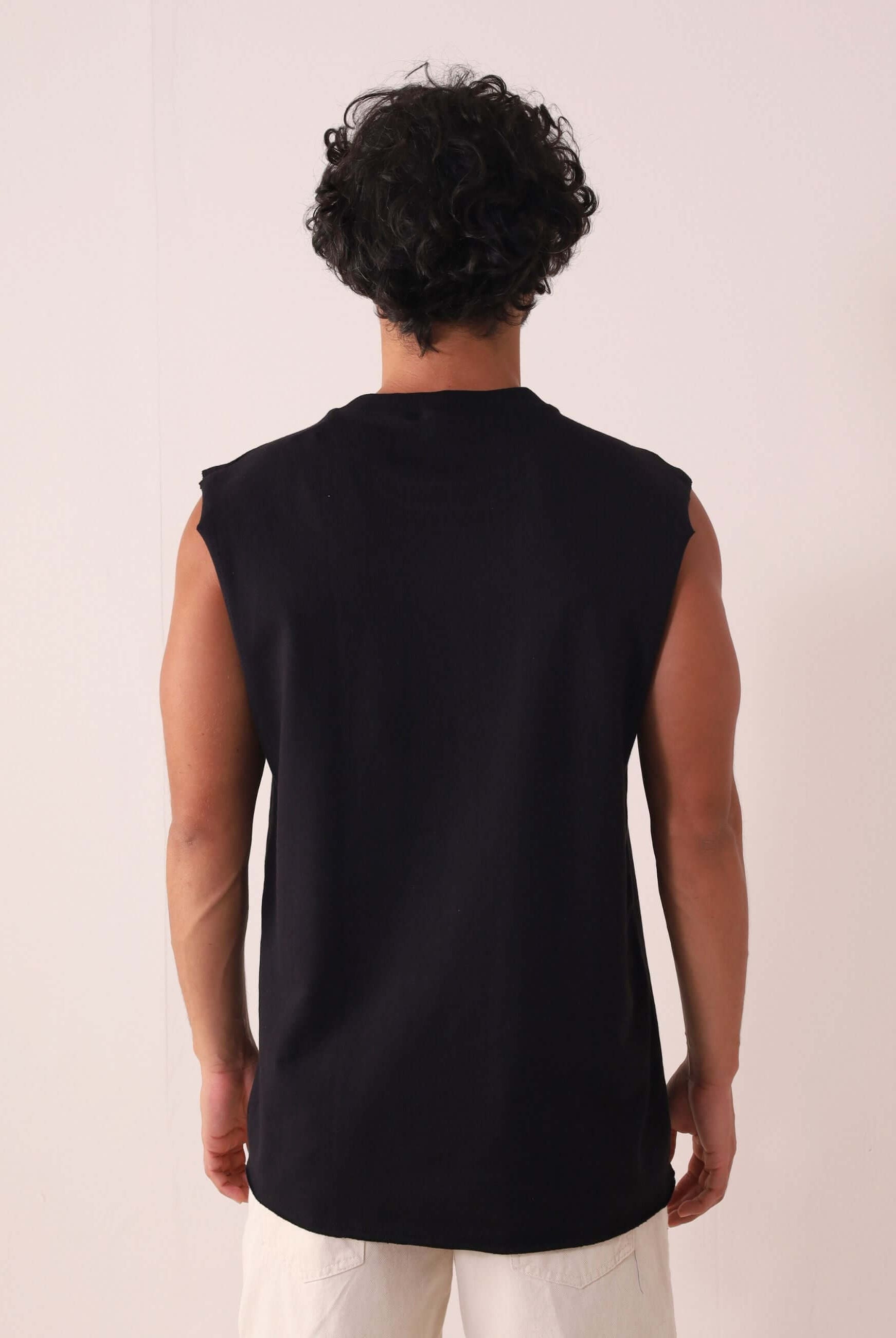 Modelo vestindo REGATA LARGA WAVES - PRETO de Greenish, vista traseira, com modelagem larga e gola em ribana, ideal para o verão.