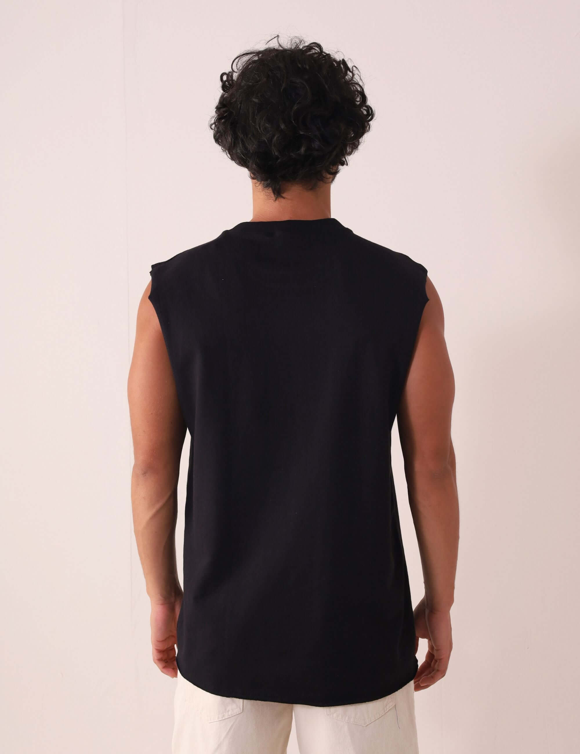 Modelo vestindo REGATA LARGA WAVES - PRETO de Greenish, vista traseira, com modelagem larga e gola em ribana, ideal para o verão.