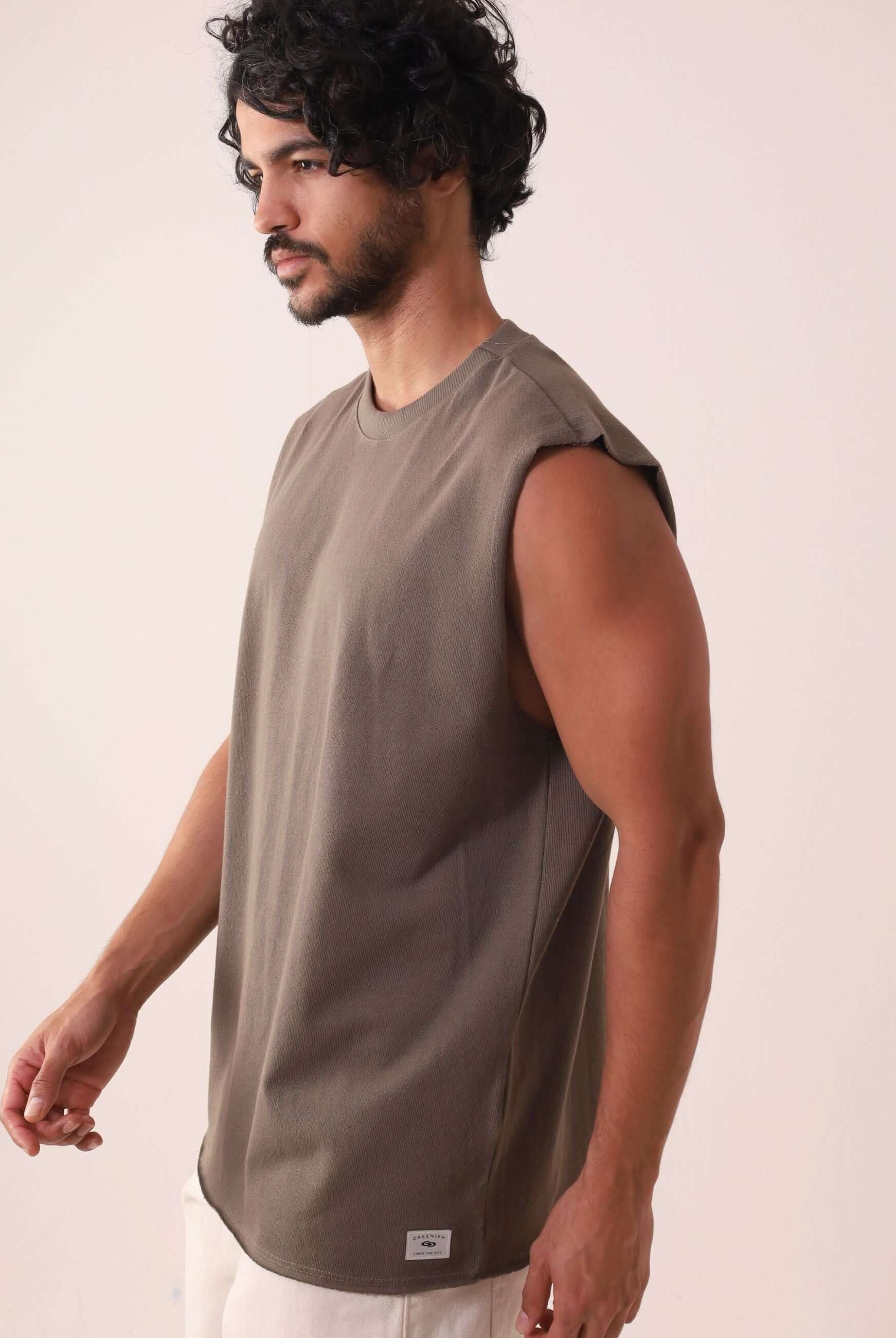 Homem vestindo REGATA LARGA WAVES - VERDE ESCURO da marca Greenish, regata de algodão com modelagem larga e gola ribana, ideal para atividades ao ar livre.