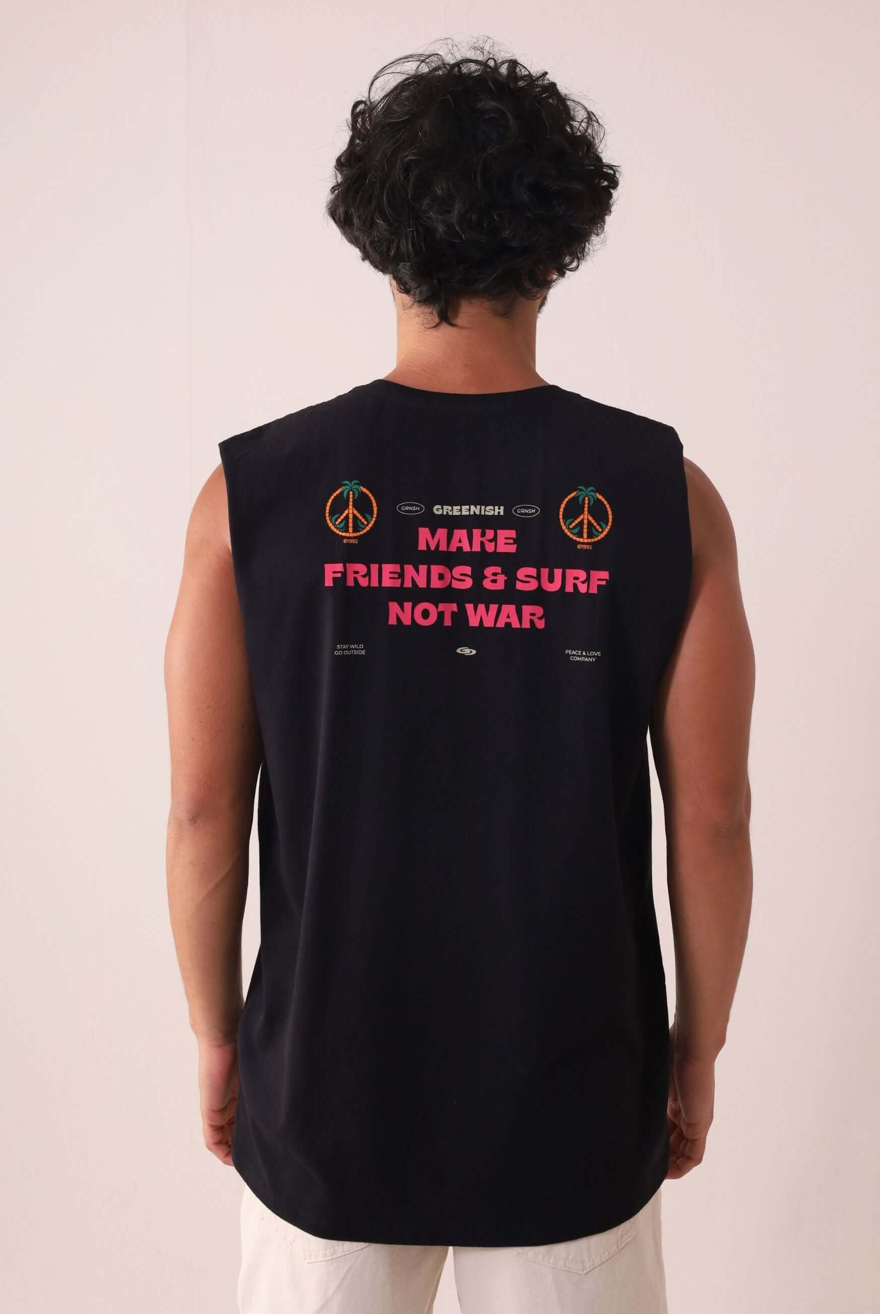 Homem vestindo Regata Make Friends - Preto da marca Greenish com estampa "Make Friends & Surf Not War" nas costas, ideal para dias de sol.