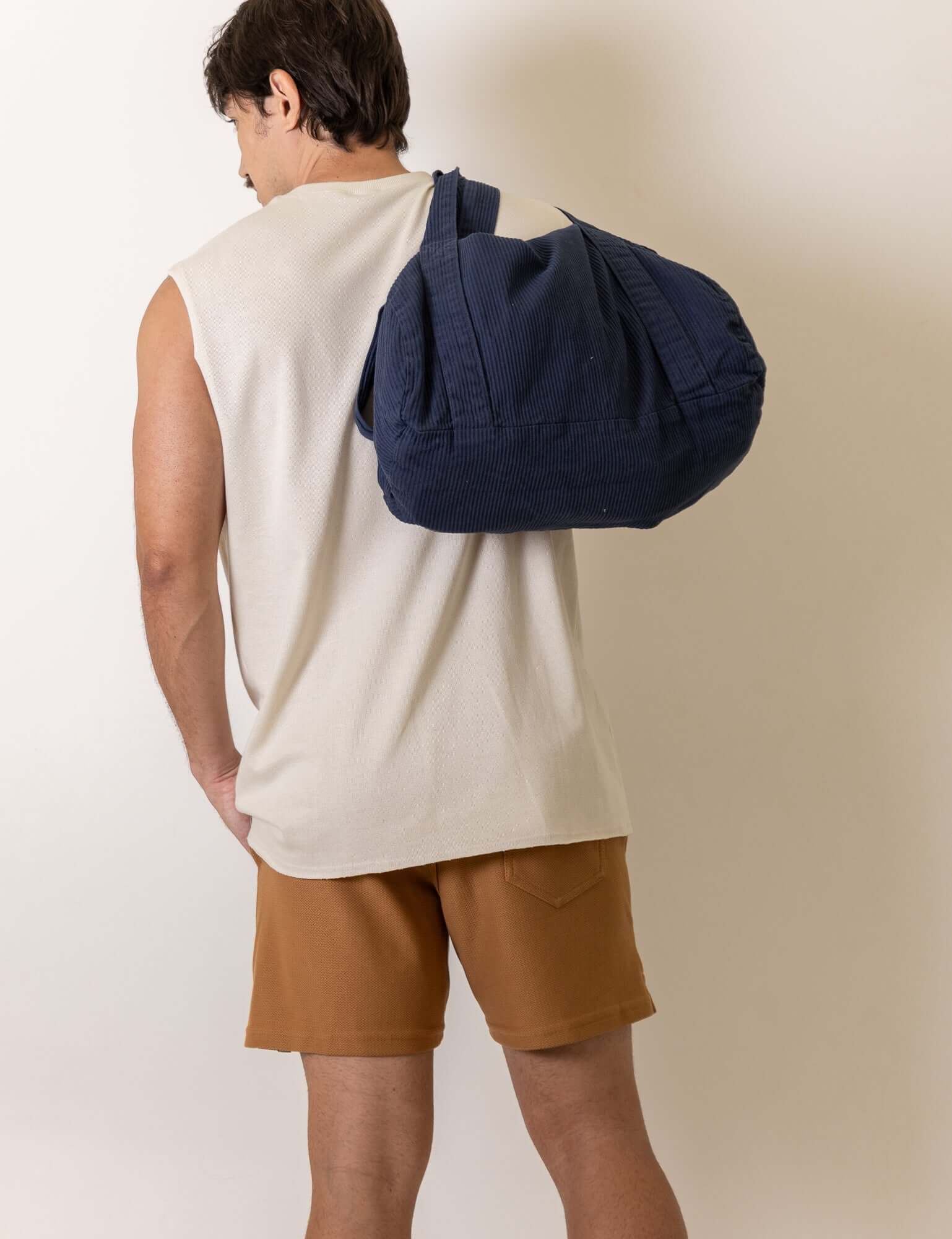 Homem usando Regata Maré - Off White da Greenish, destacando-se pela modelagem ampla e conforto, ideal para dias ensolarados.