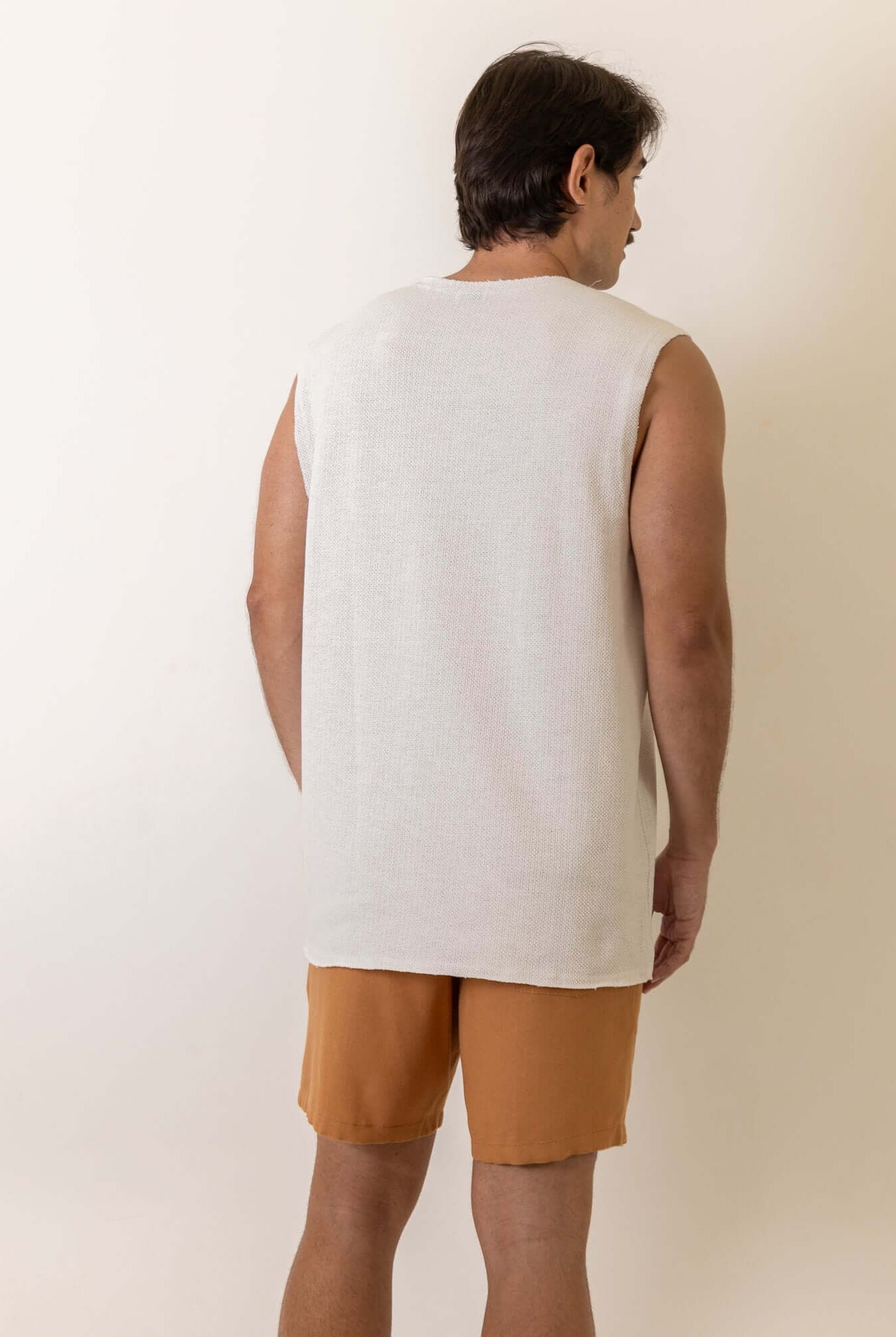 Greenish Regata Maré - Off White: A model wearing a minimalist, comfortable sleeveless shirt with a subtle side label detail.