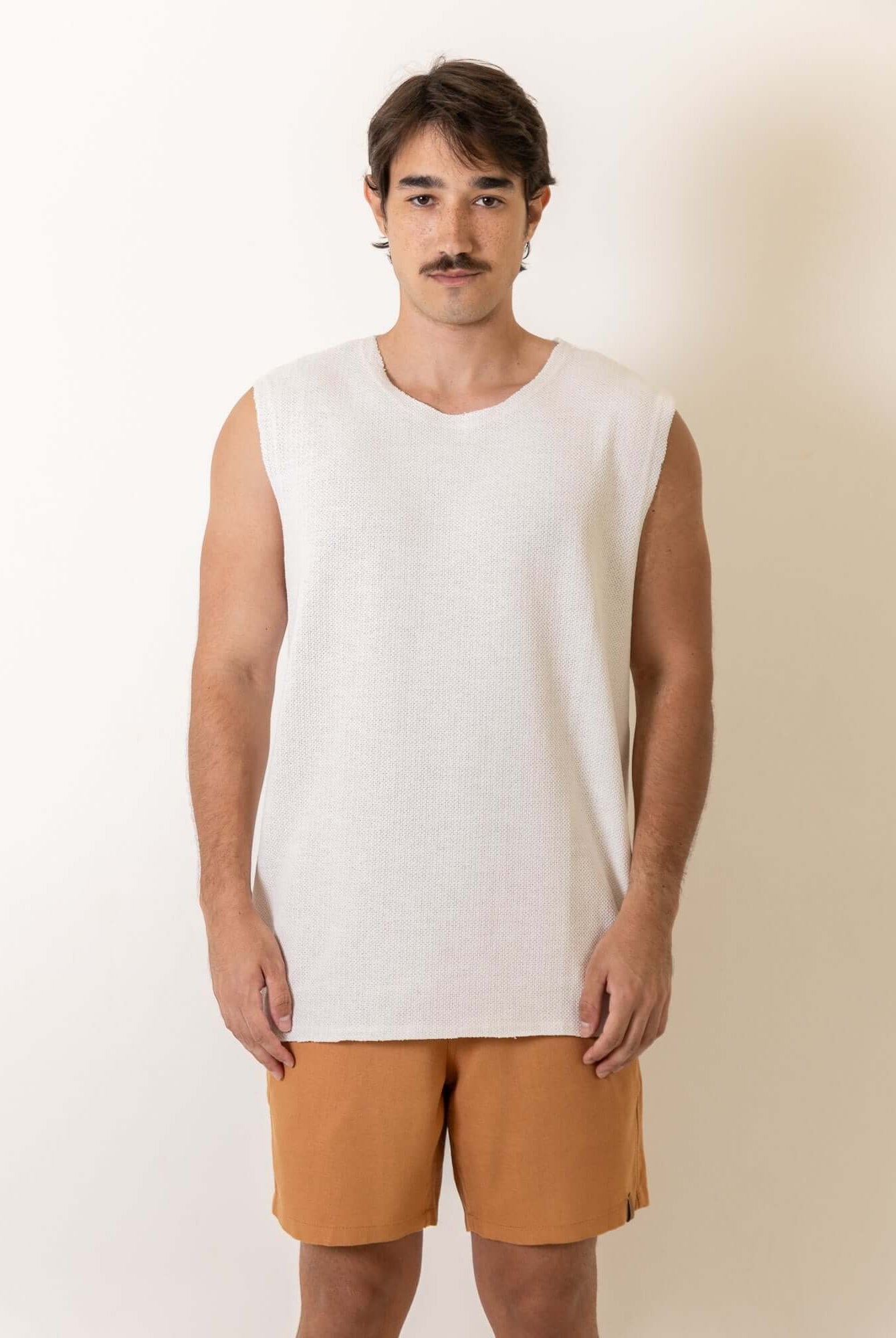 Homem usando Regata Maré - Off White da marca Greenish, modelagem ampla e confortável, ideal para dias de céu aberto.