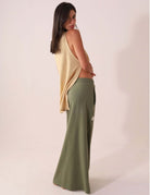 Modelo vestindo SAIA MIDI DÉA - VERDE CLARO da Greenish, saia canelada com fenda lateral e cós elástico, elegante e confortável.