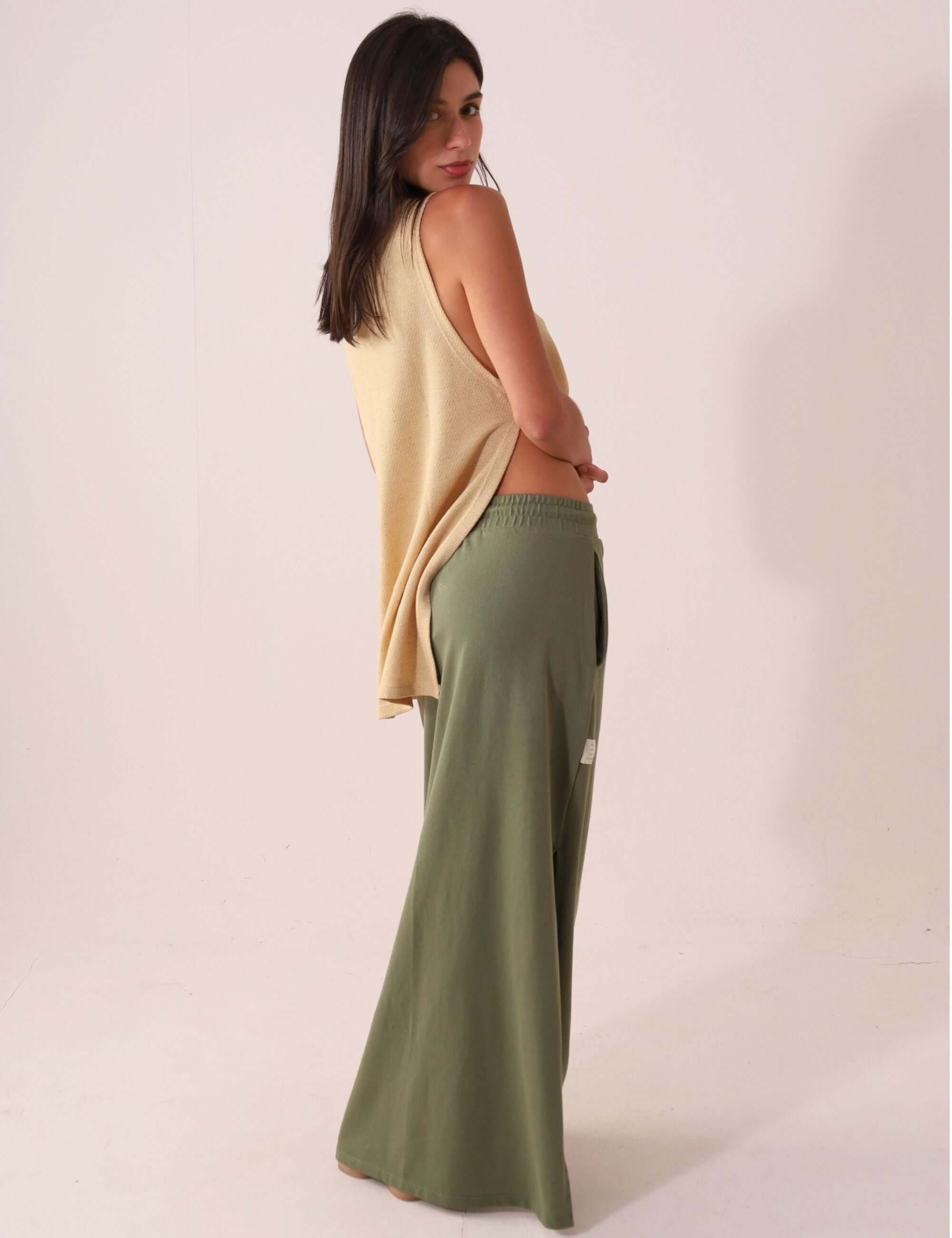 Modelo vestindo SAIA MIDI DÉA - VERDE CLARO da Greenish, saia canelada com fenda lateral e cós elástico, elegante e confortável.