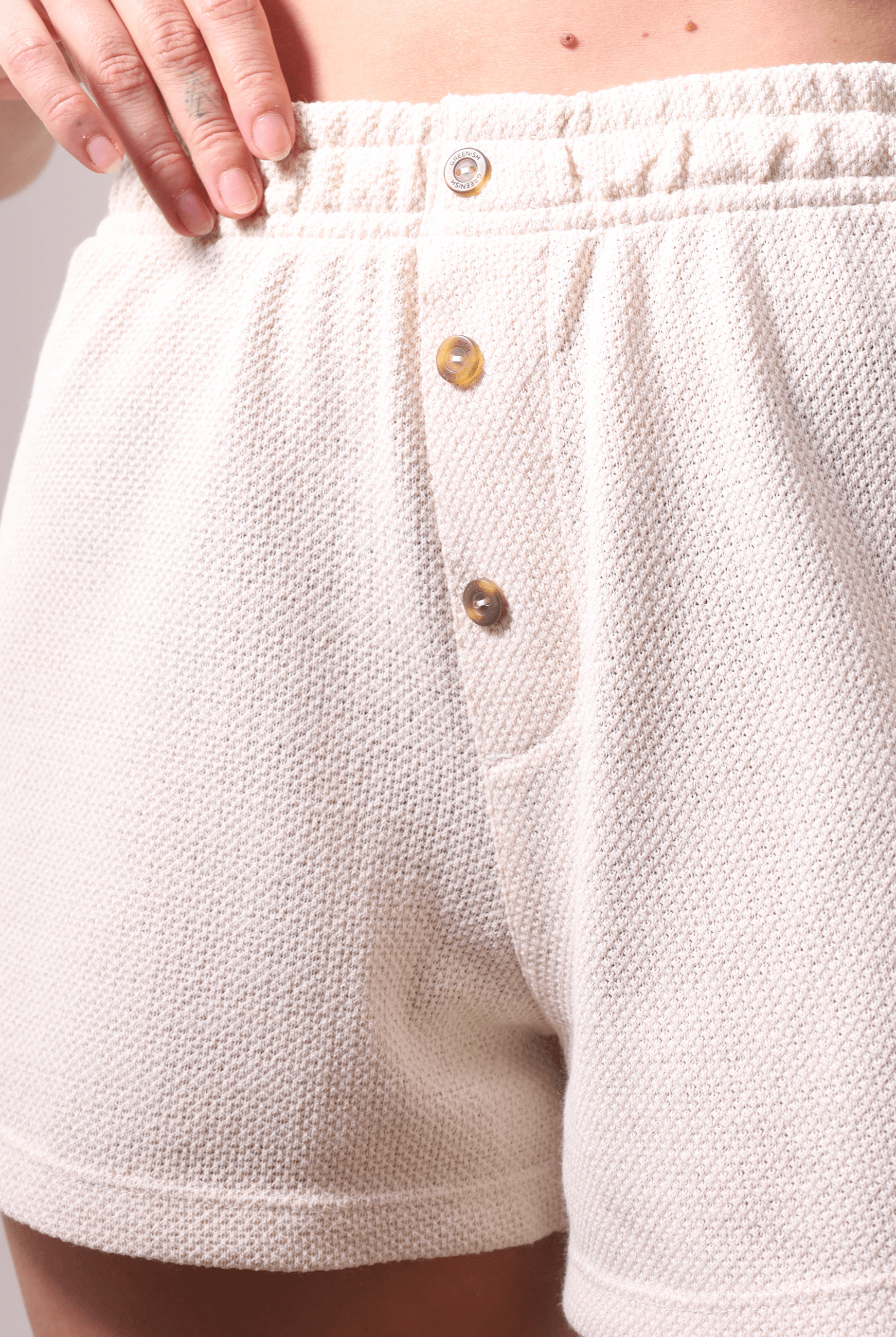 Short Malu Bege da Greenish com cintura alta e botões, tecido macio e rústico, destacando conforto e estilo casual.