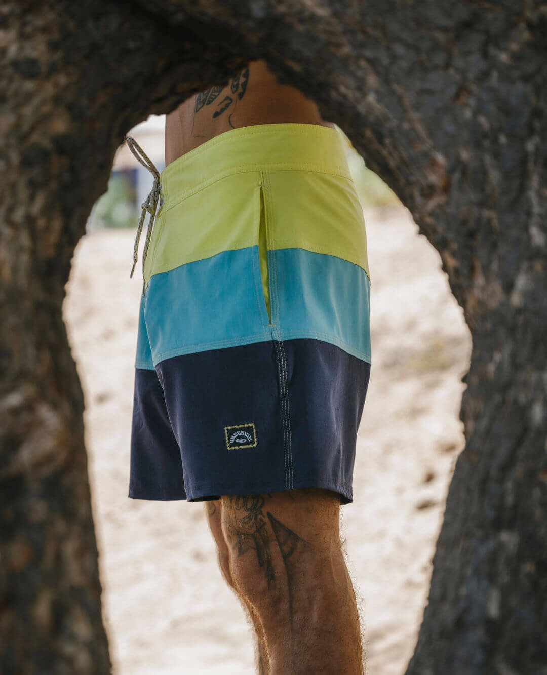 Calção Boardwalk Three Panels da Greenish com recortes em azul, amarelo e marinho, ideal para dias de praia e conforto.