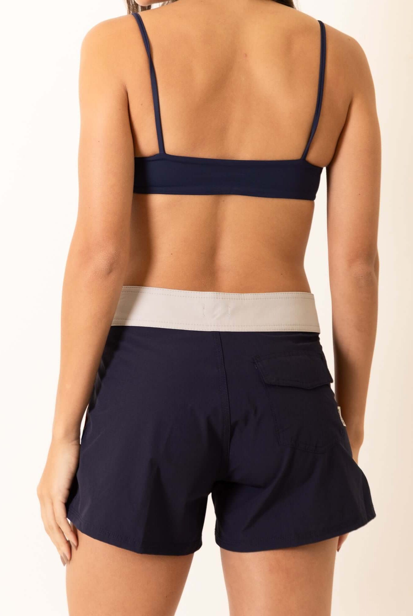 Mulher vestindo Biquini Fixo Essential - Azul Marinho da marca Greenish, vista traseira destacando a cor vibrante e estilo confortável.