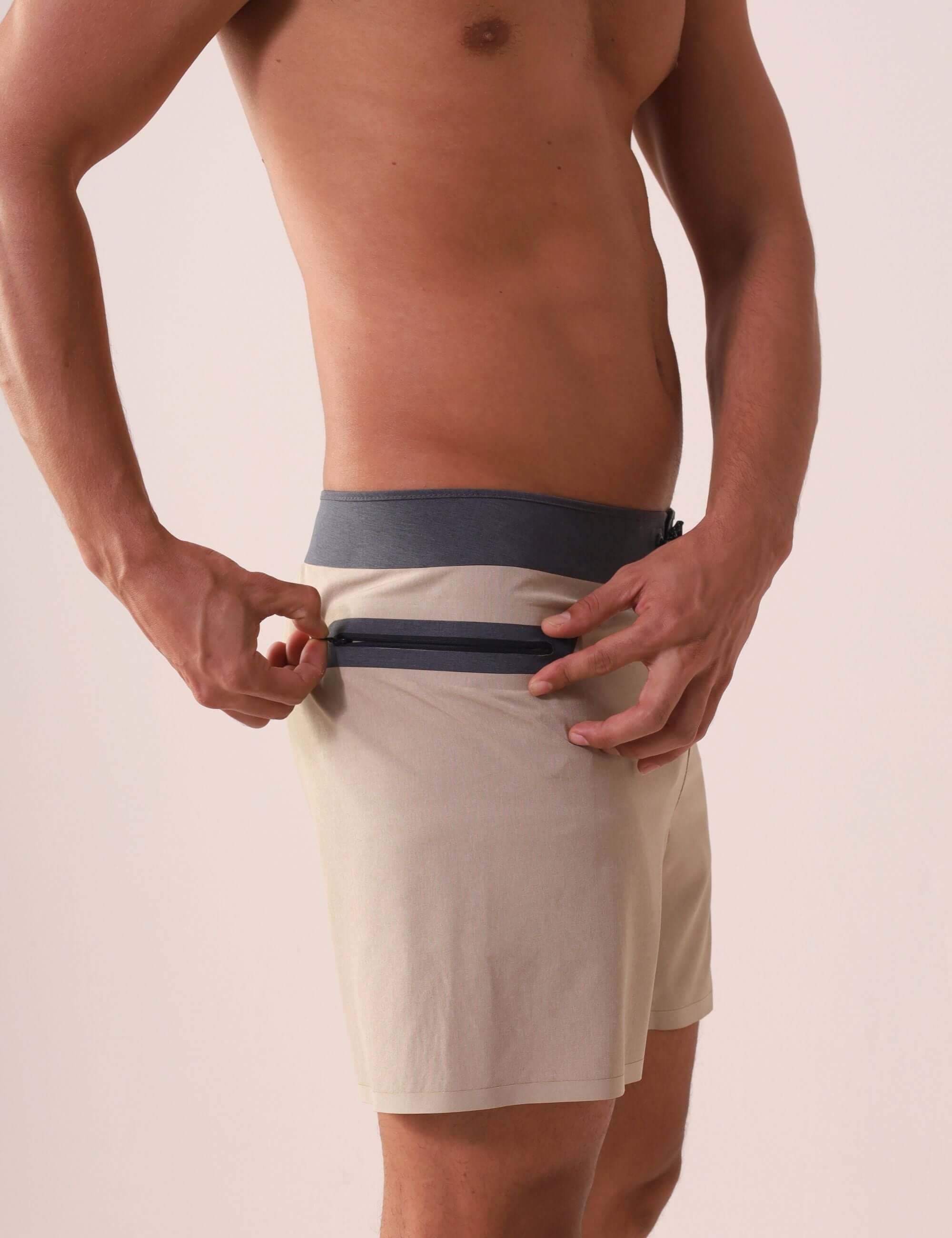 Homem usando o Boardshort Ultralight II Color - Caqui da Greenish, destacando o bolso com zíper para conforto e performance no surfe.