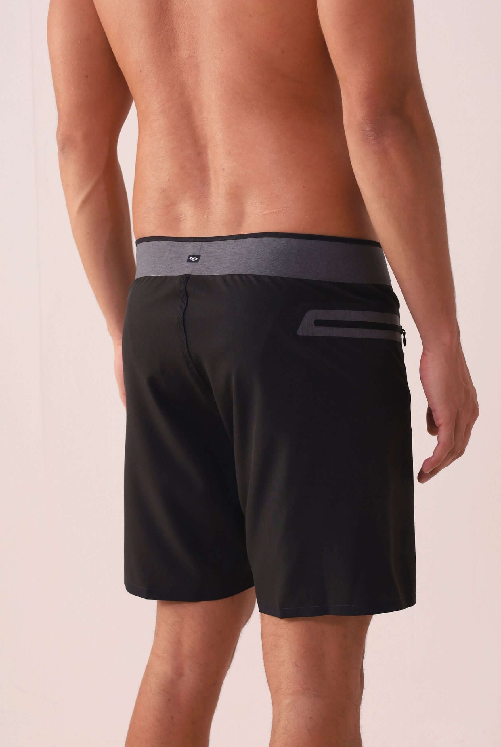 Modelo vestindo Boardshort Ultralight II Ocean - Preto Greenish com cós anatômico e bolso lateral, foco em performance e leveza.