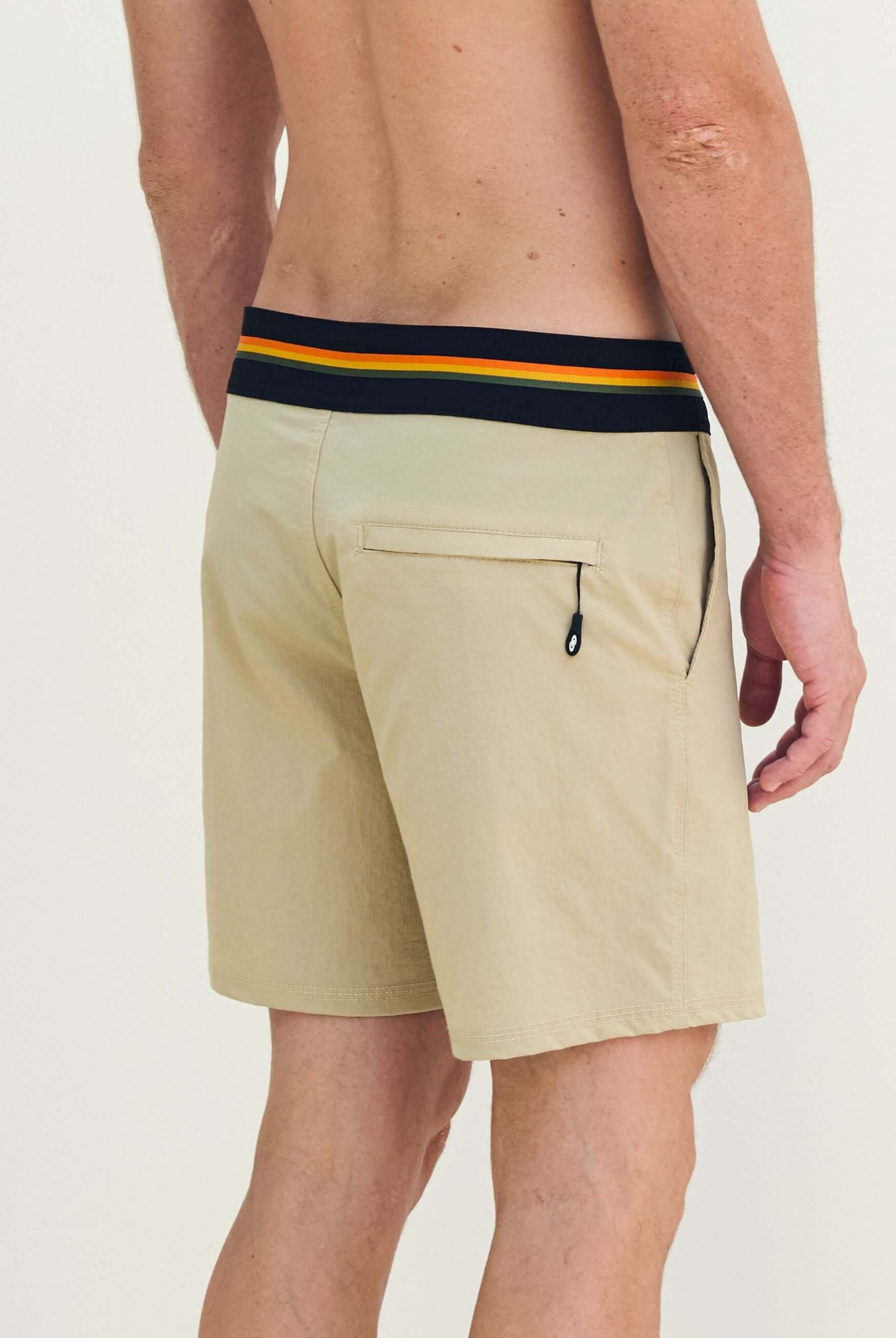 Man wearing Boardwalk Outline Backoutdoor - Areia shorts with vibrant striped waistband, perfect for casual outings.